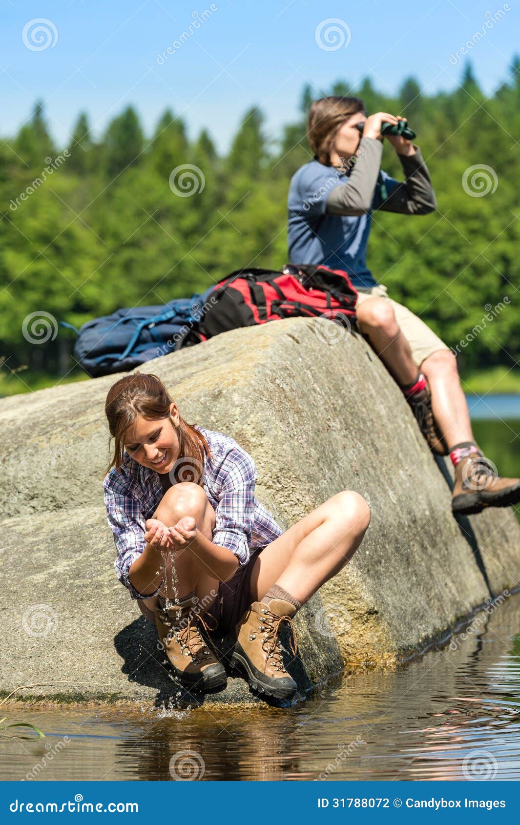 teenagers resting and birdwatching by lake