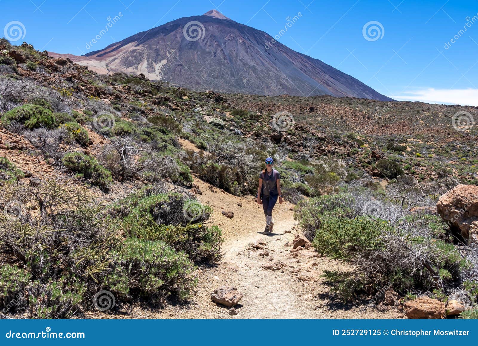 teide - woman on hiking trail la fortaleza from el portillo. panoramic view on volcano pico del teide