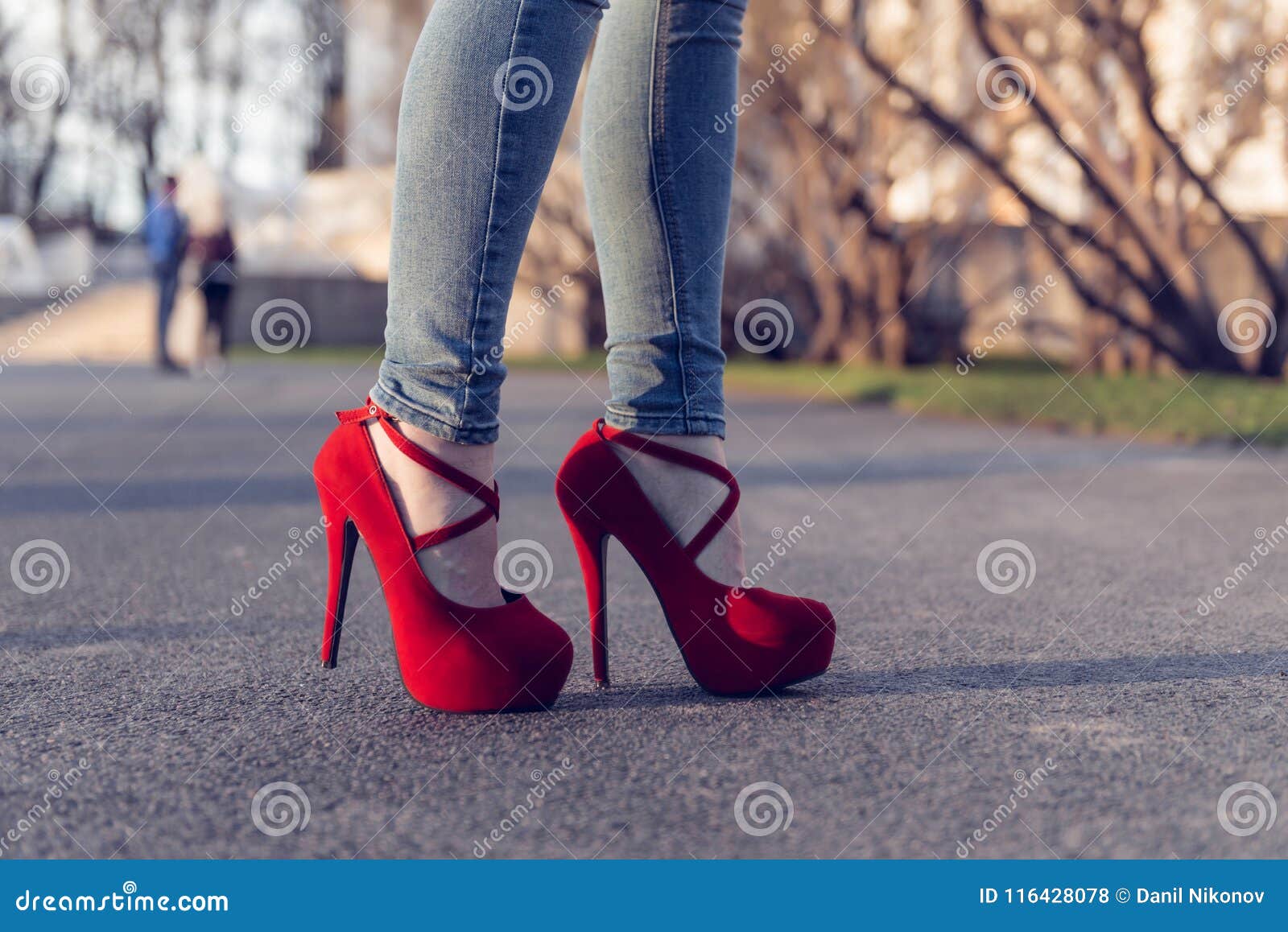 Tejanos Que Llevan De La Mujer Y Zapatos Rojos Del Tacón Alto Los Tacones  Altos De La Ropa De Mujer Que Se Colocan En El Camino P Foto de archivo -  Imagen