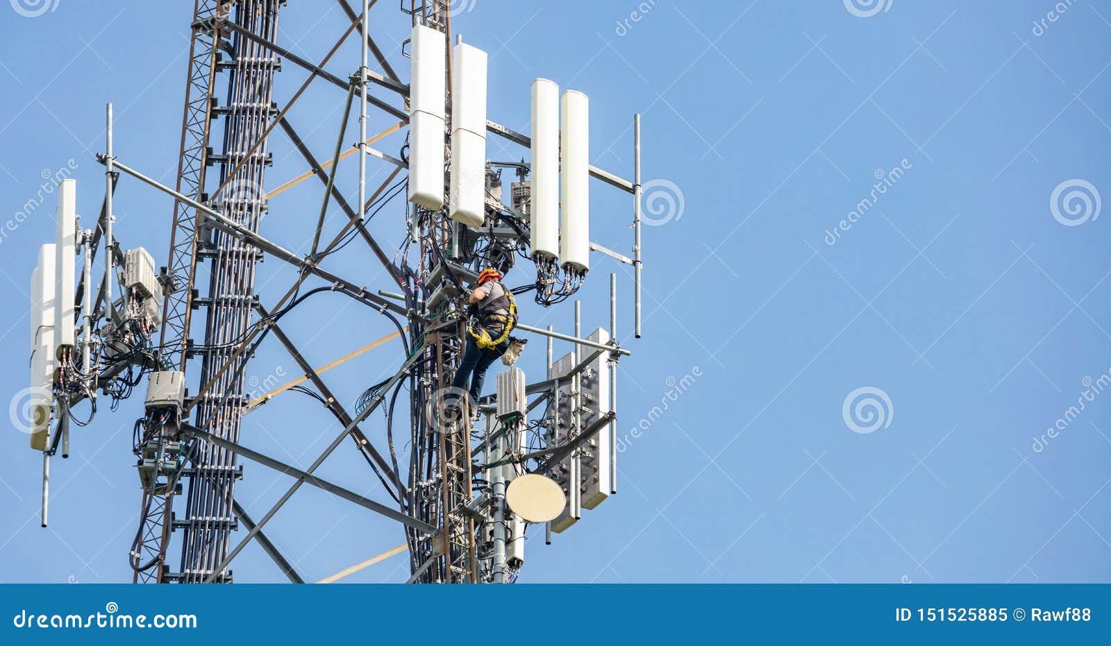 telecom maintenance. two repair men climbing on tower against blue sky background