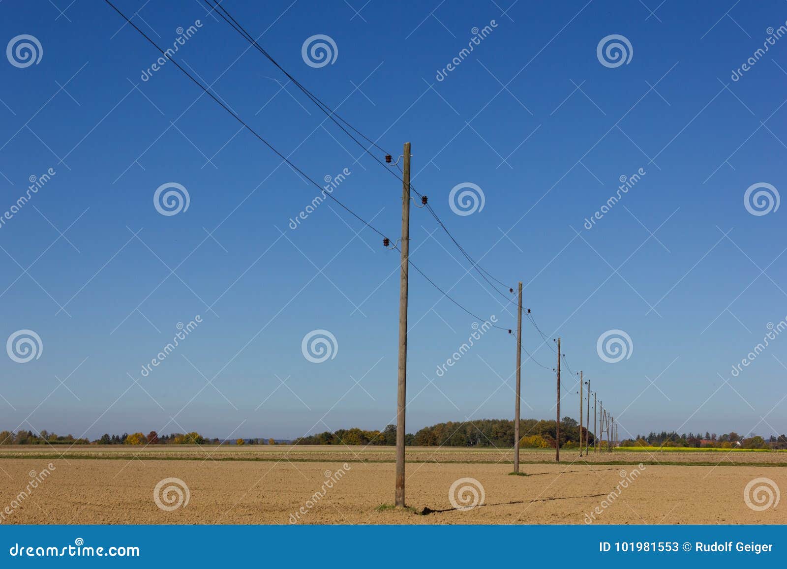 telegraph pole beside a bikeway and white tower on a plain field