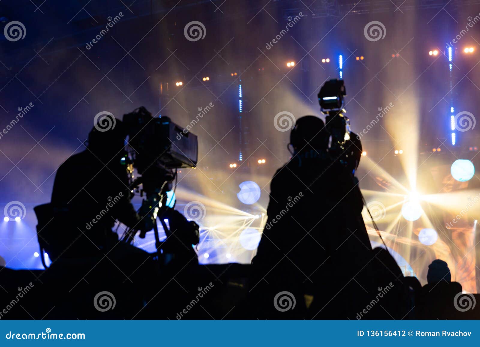television broadcast by a cameraman during a concert. camera with the operator is on the high platform