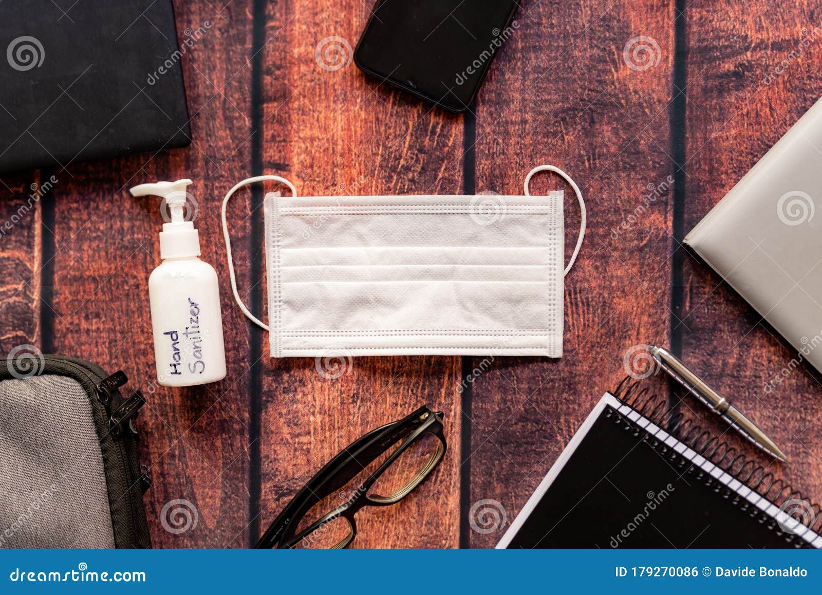 telework kit on wooden home office desk with hand sanitizer and protective mask, a solution against the spread of corona virus for