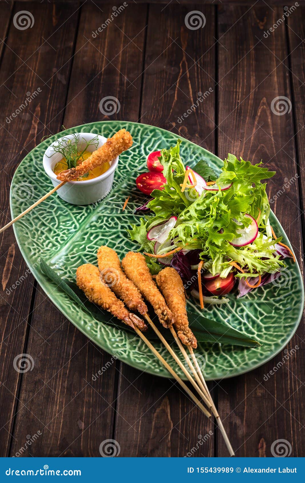 Tempura dos camarões com salada fresca na placa verde com um teste padrão Fundo marrom de madeira Culin?ria japonesa tradicional