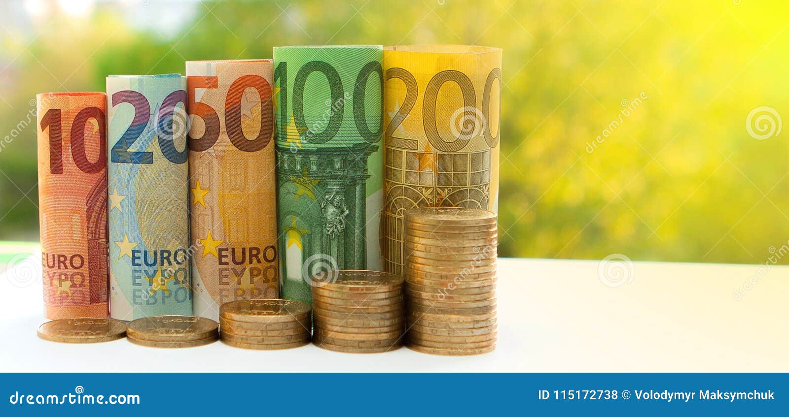 ten, twenty, fifty, one hundred, two hundred and coins euro rolled bills banknotes on green blurred bokeh background. histogram fr