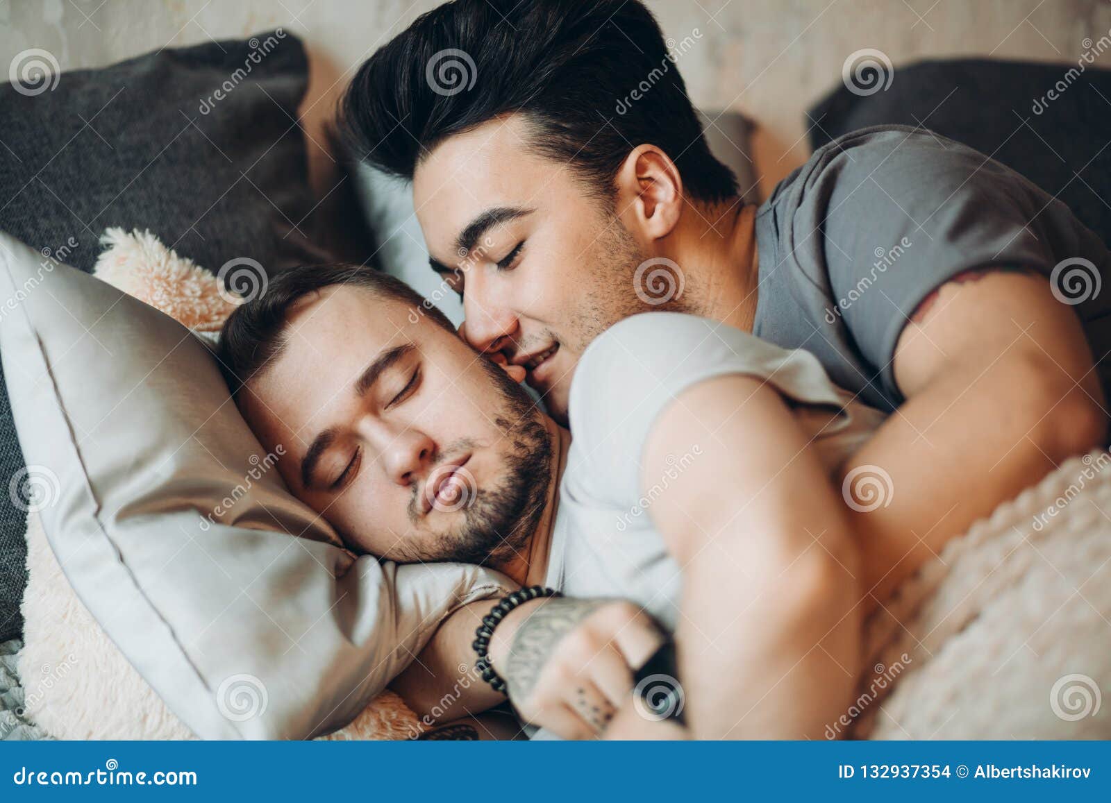 Positive Delighted Non-traditional Couple Sleeping Together Stock Photo photo image