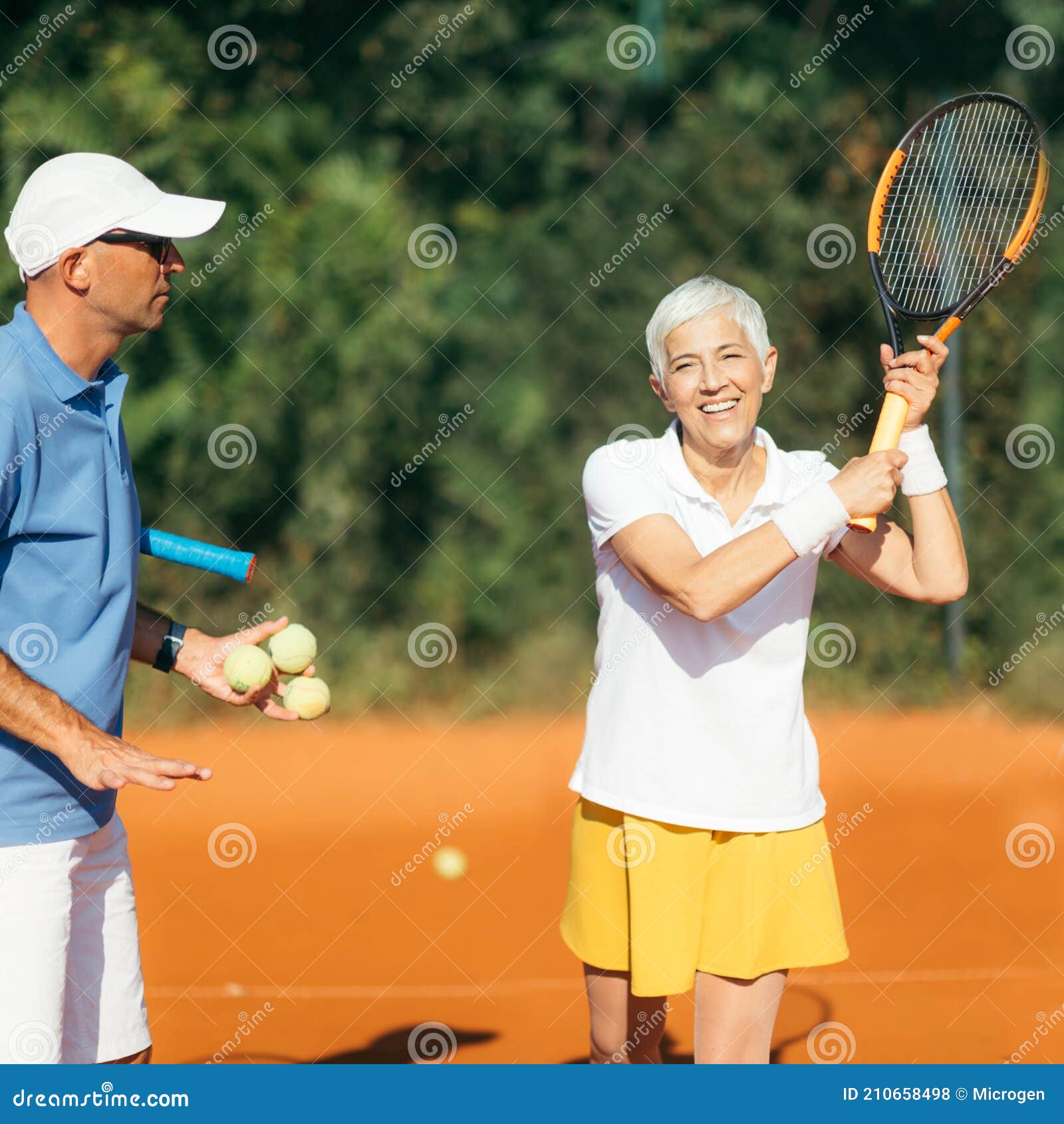 Tennis Instructor with Senior Woman, Tennis Training Lesson Stock Photo