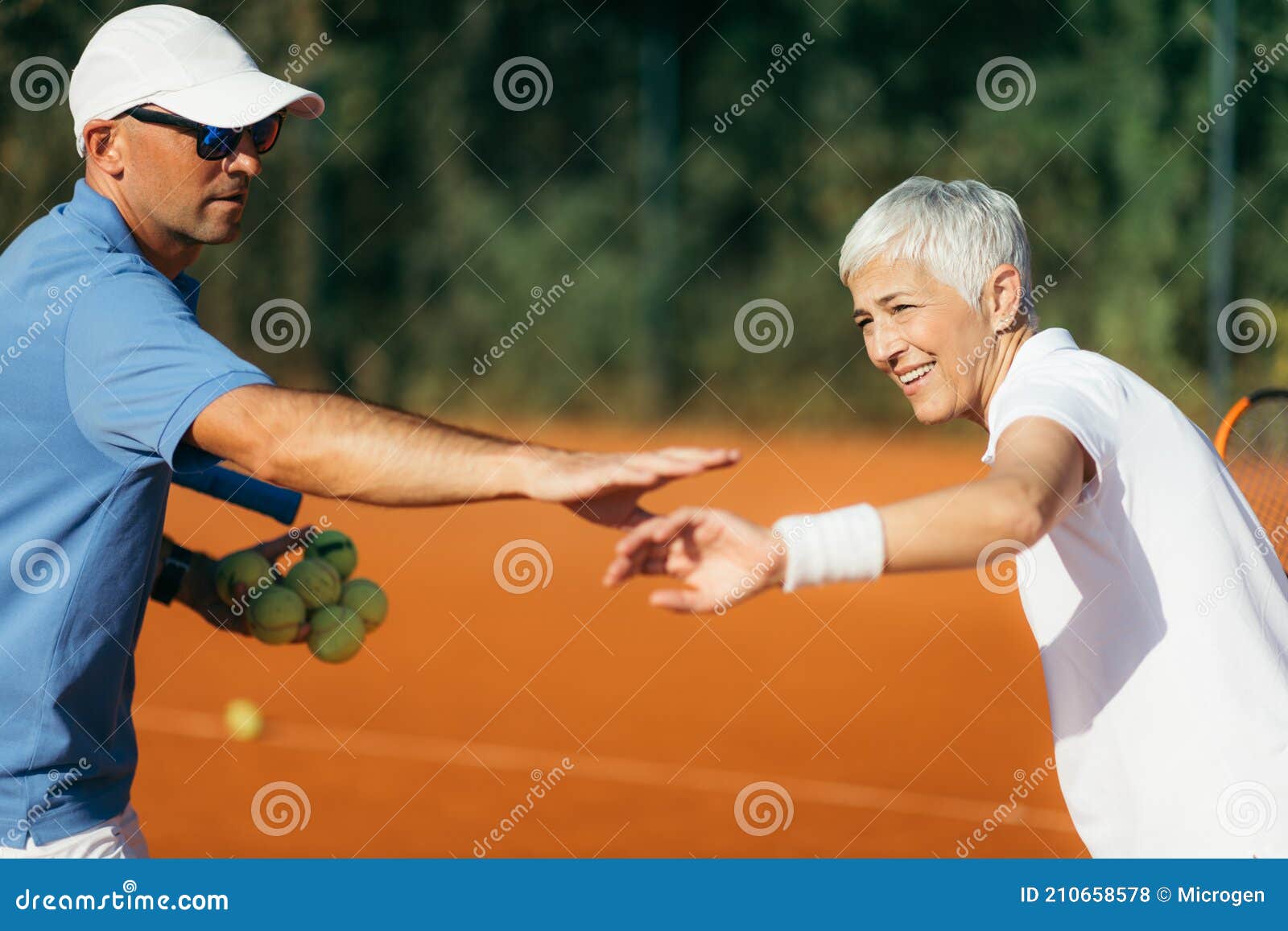 Tennis Instructor with Senior Woman, Tennis Training Lesson Stock Photo