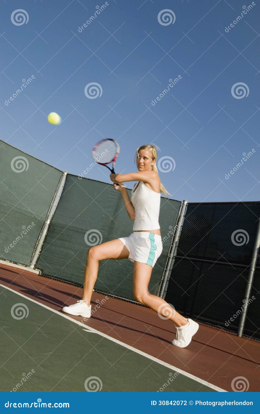 tennis player hitting backhand on court
