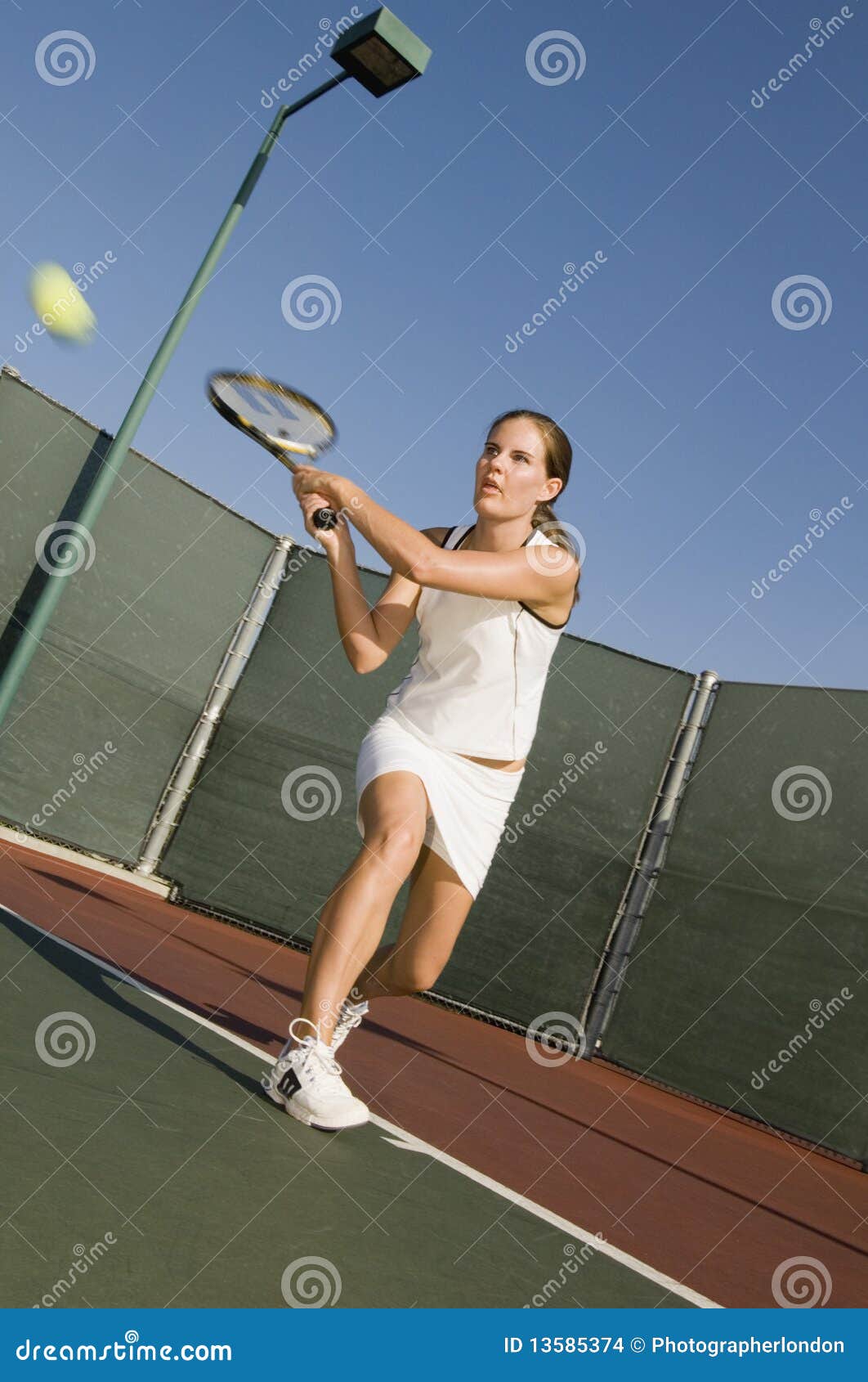 tennis player hitting backhand on tennis court