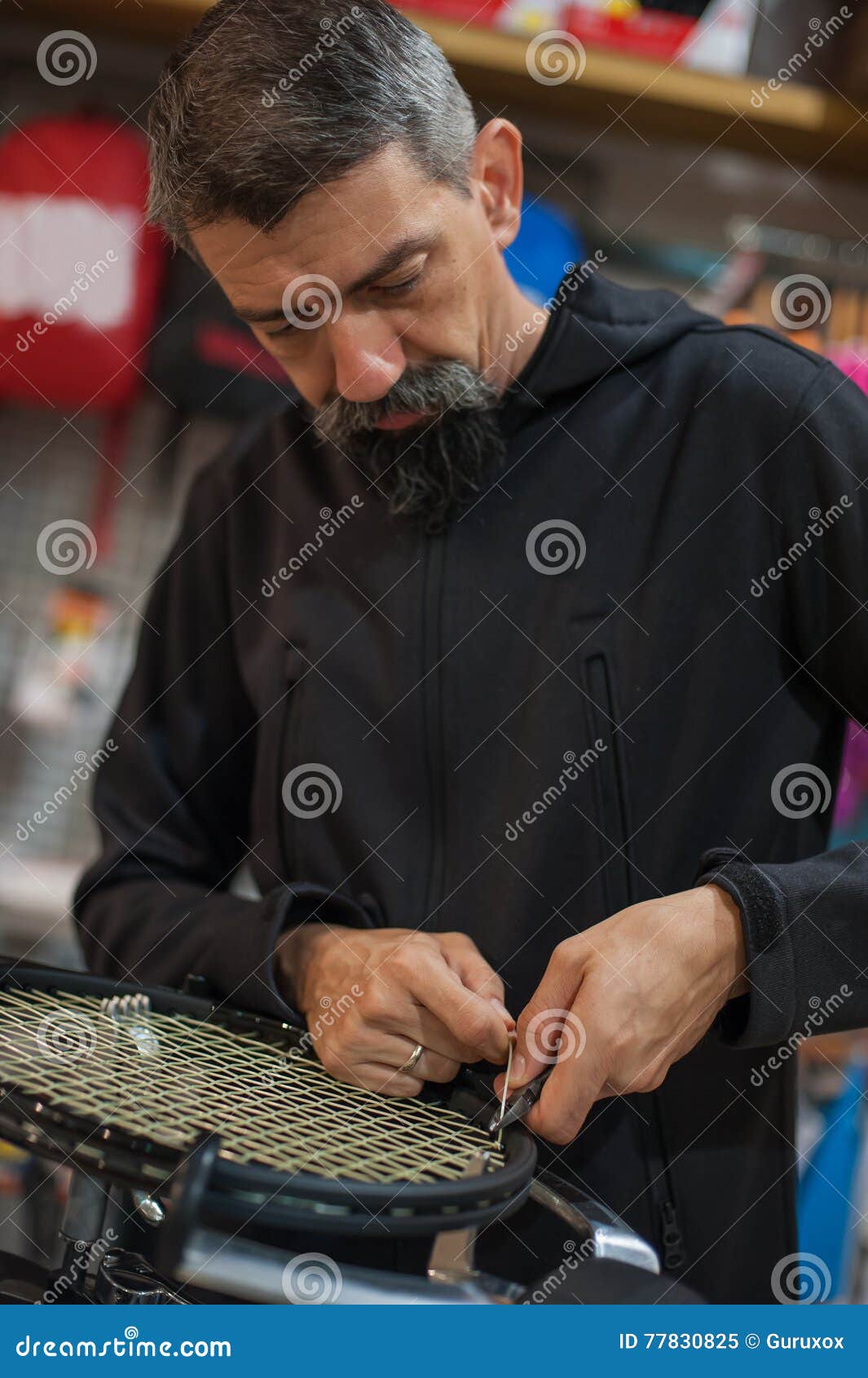 Tennis Stringer Tying Knots and Cutting String with Pliers Stock Image