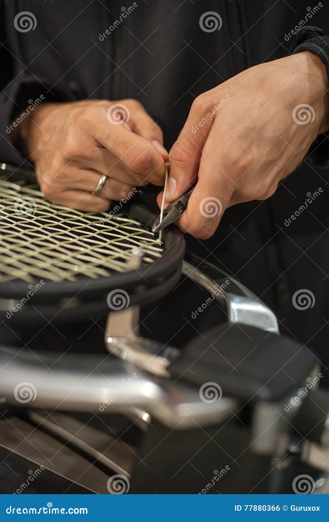 Tennis Stringer Tying Knots and Cutting String with Pliers Stock Photo