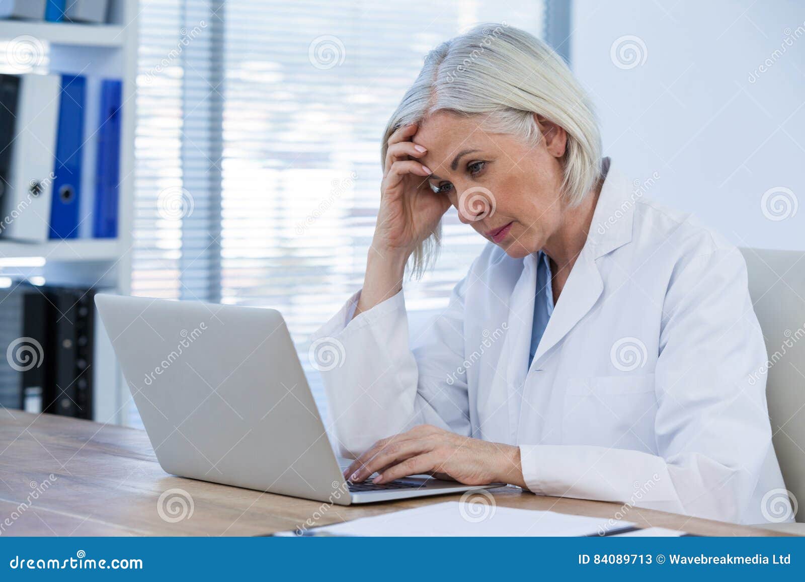 tense female doctor working on her laptop