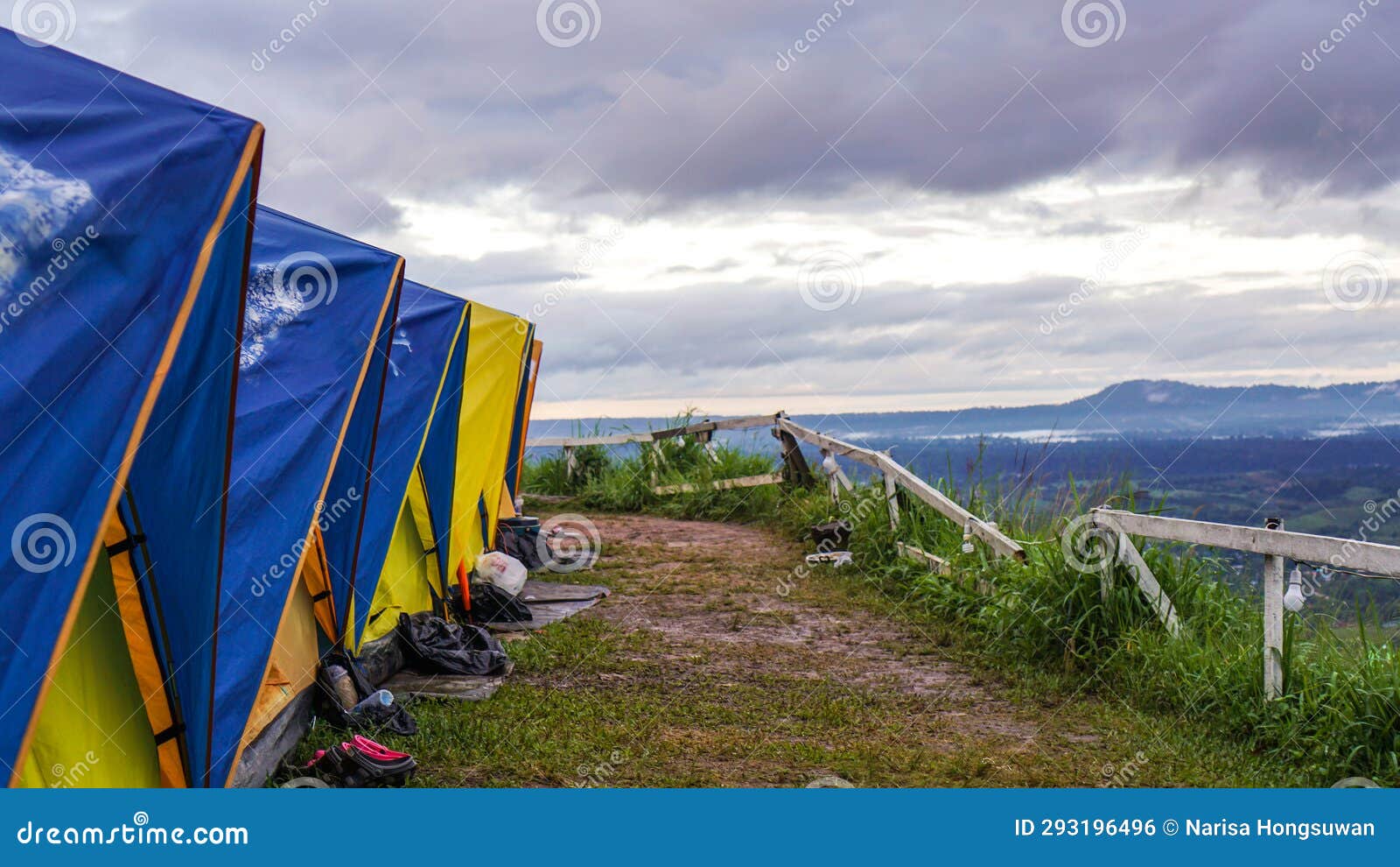 tent in camping with flog and mountain view. camping activities in rain-filled holiday. tent on campsite by the hill in rainy day