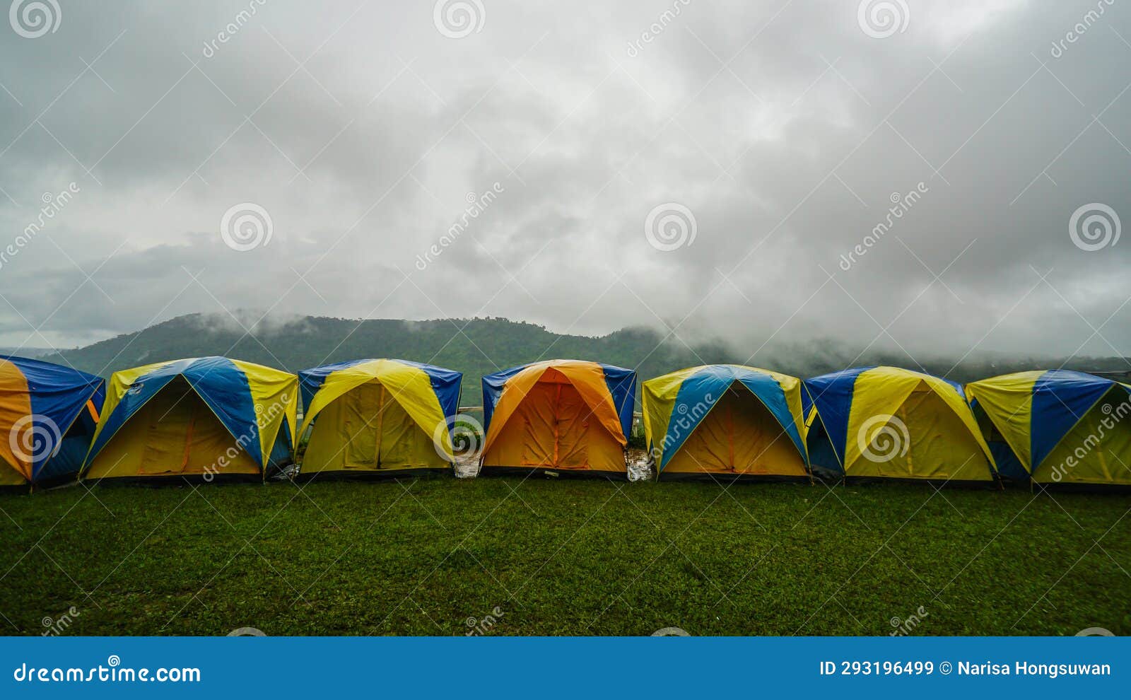 tent in camping with flog and mountain view. camping activities in rain-filled holiday. tent on campsite by the hill in rainy day
