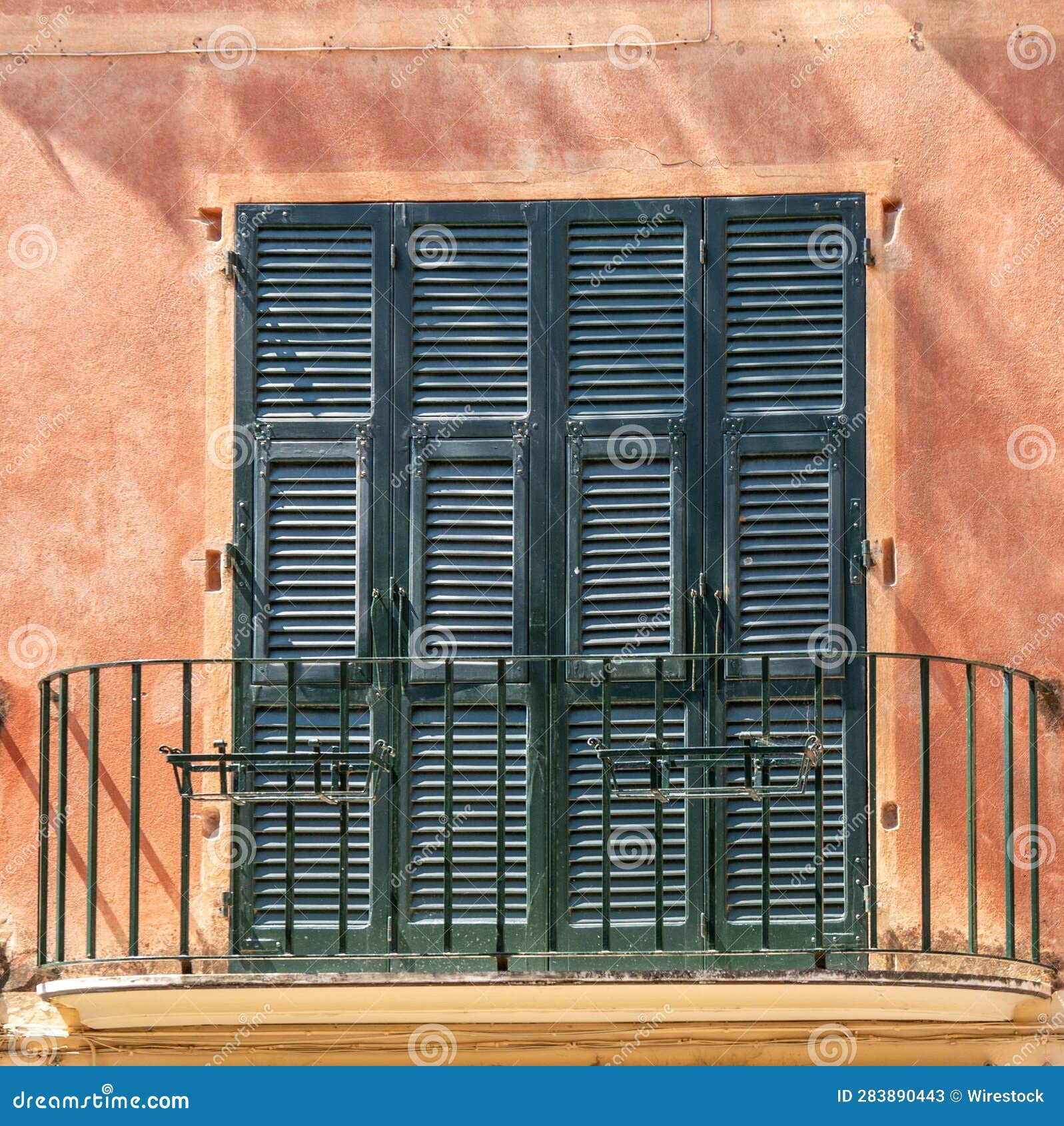 Terrace Featuring Dark Green Window Shutters on an Orangecolored