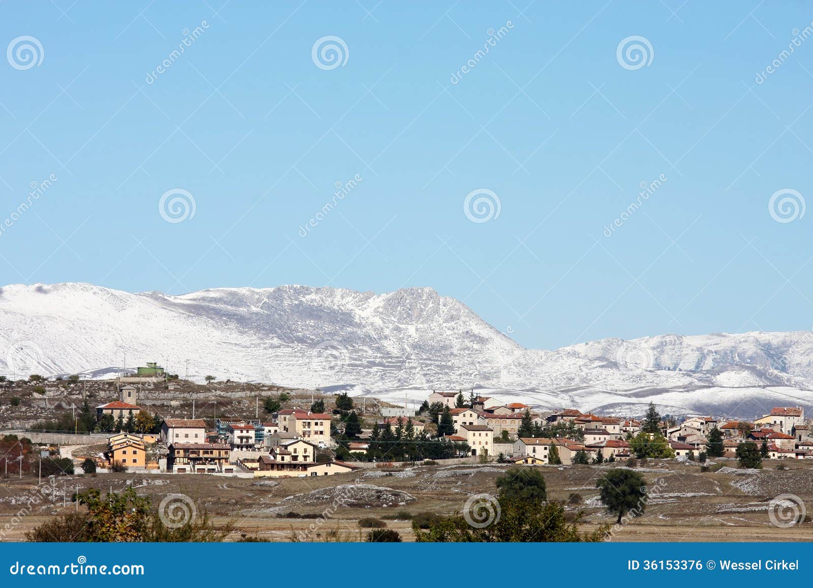 Terranera against snow-capped mountains, Italy. Terranera is a village at the Rocche plateau in the Sirente-Velino Regional Park in the Italian province of L Aquila in Abruzzo. The park is centered around the Monte Velino and Monte Sirente massifs. In autumn snow has covered for the first time the mountains with a thin white layer.