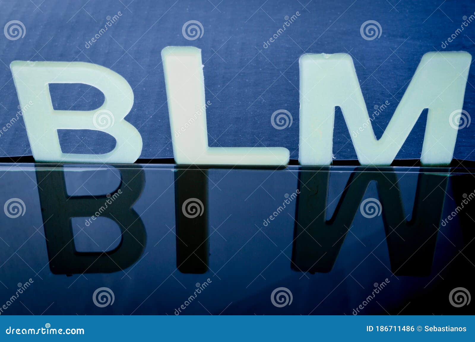 The Text BLM Written in Plastic Letters on a Black Mirroring Surface