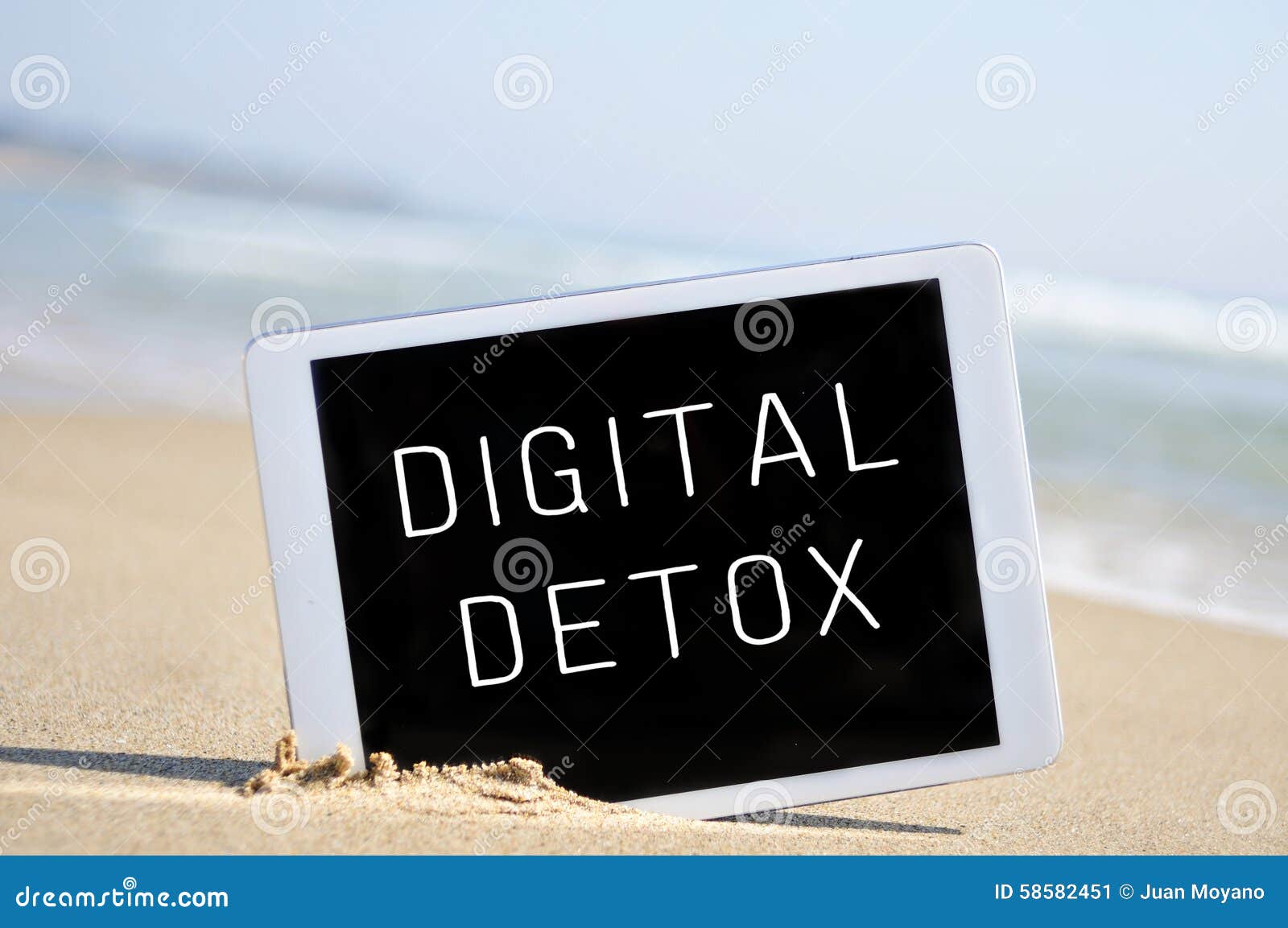 text digital detox in a tablet computer, in the sand of a beach