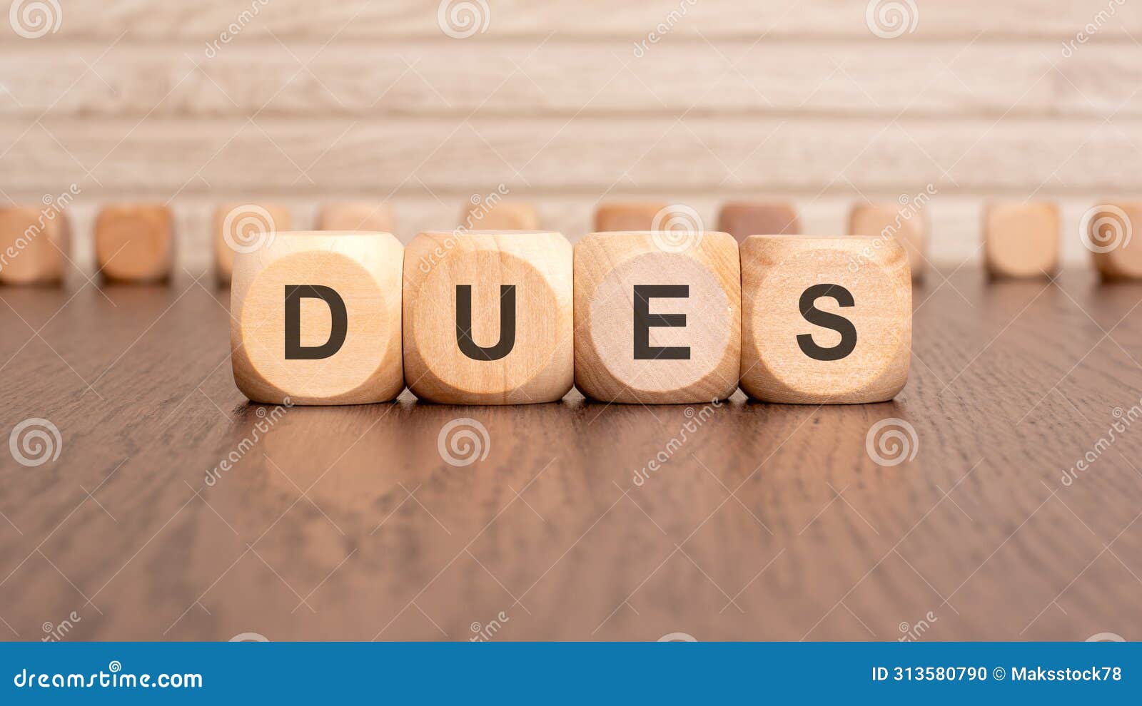 the text dues is written on wooden cubes on a brown background