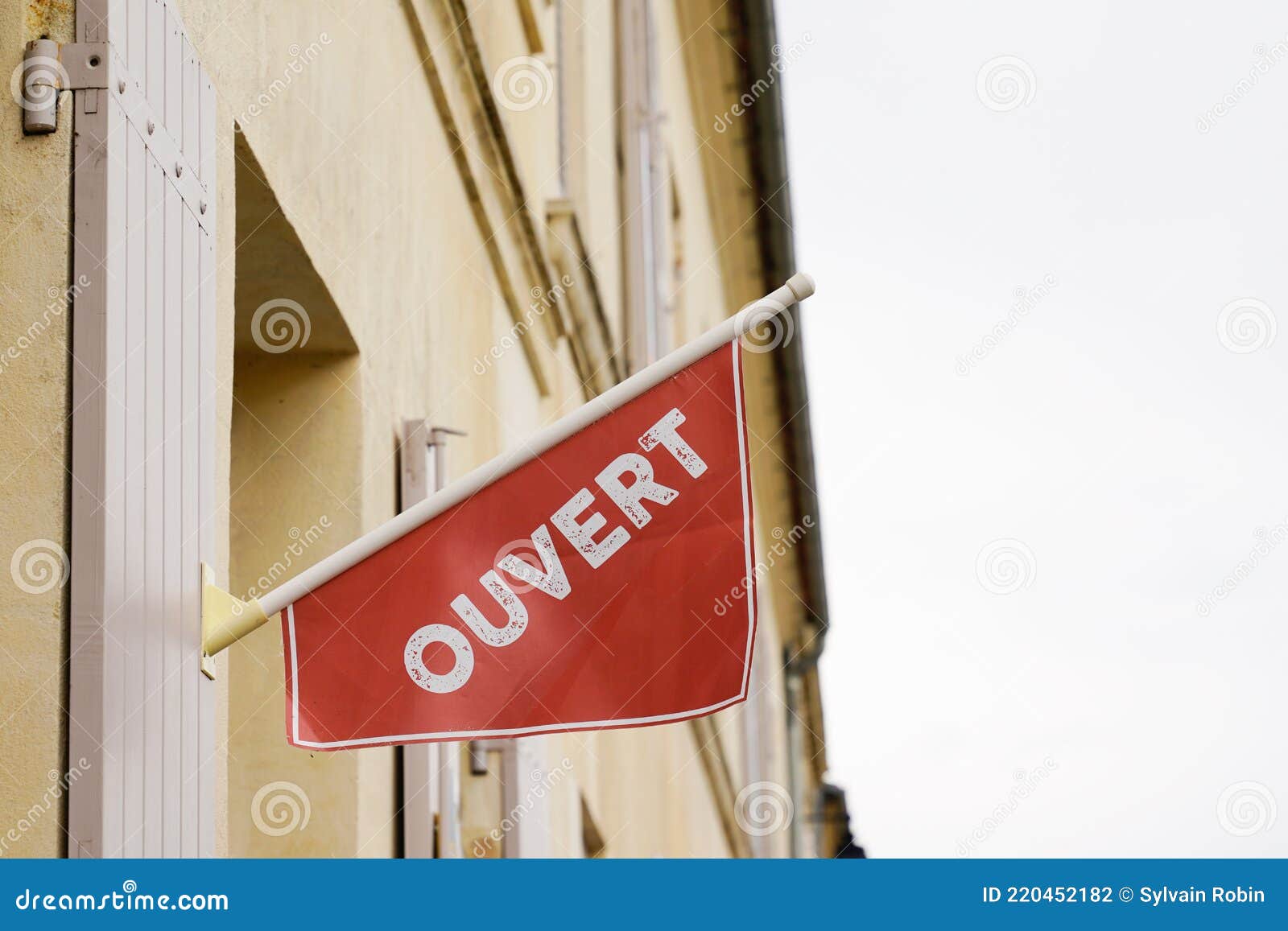 Red and blue sign in the window of a shop saying in French Ouvert, meaning  in English Open Stock Photo - Alamy