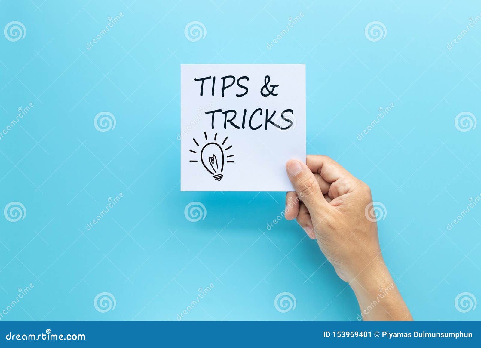 text tips and tricks on white paper in hand  on blue background.