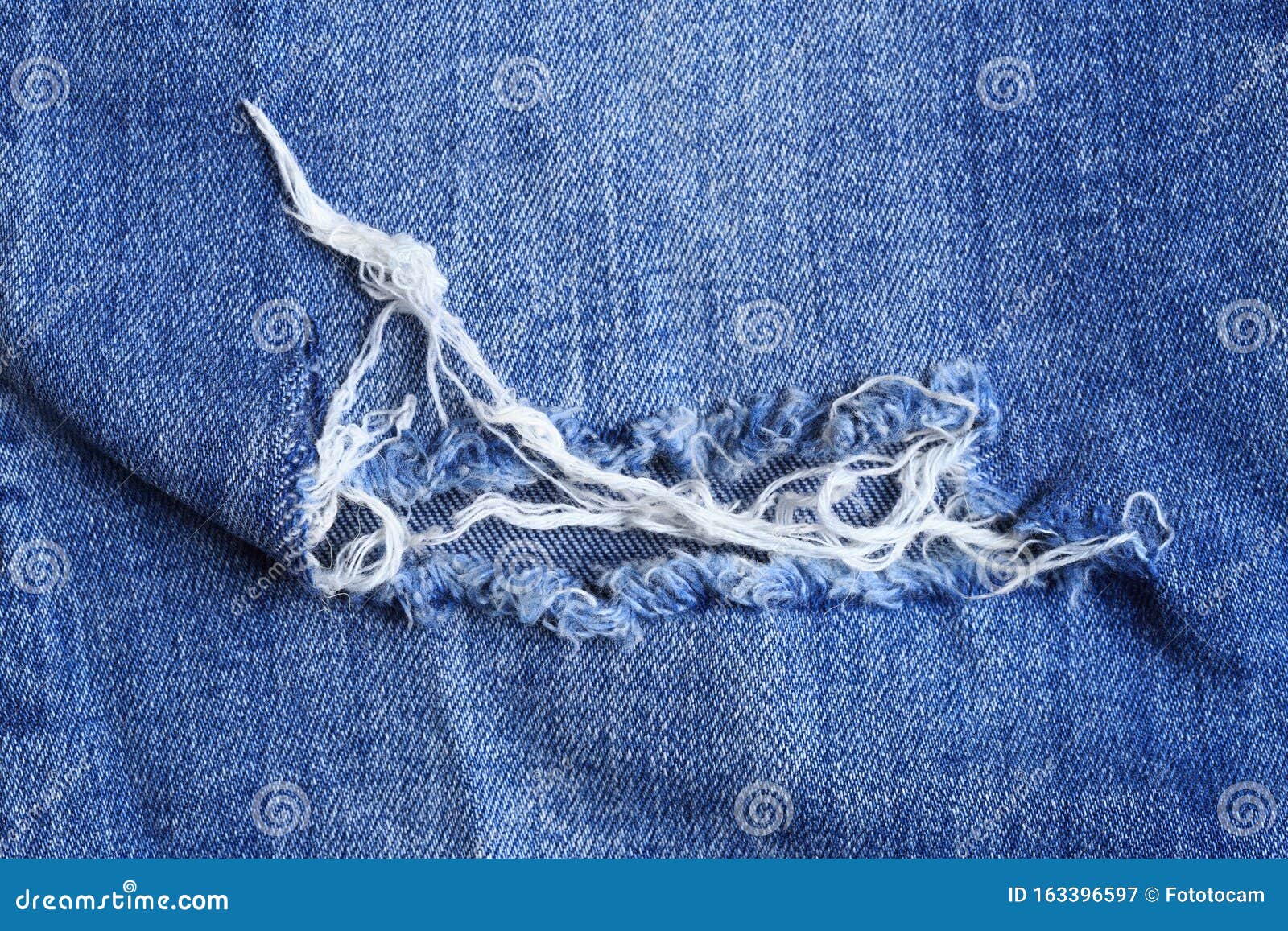 Closeup of torn old blue jeans background. texture of ripped