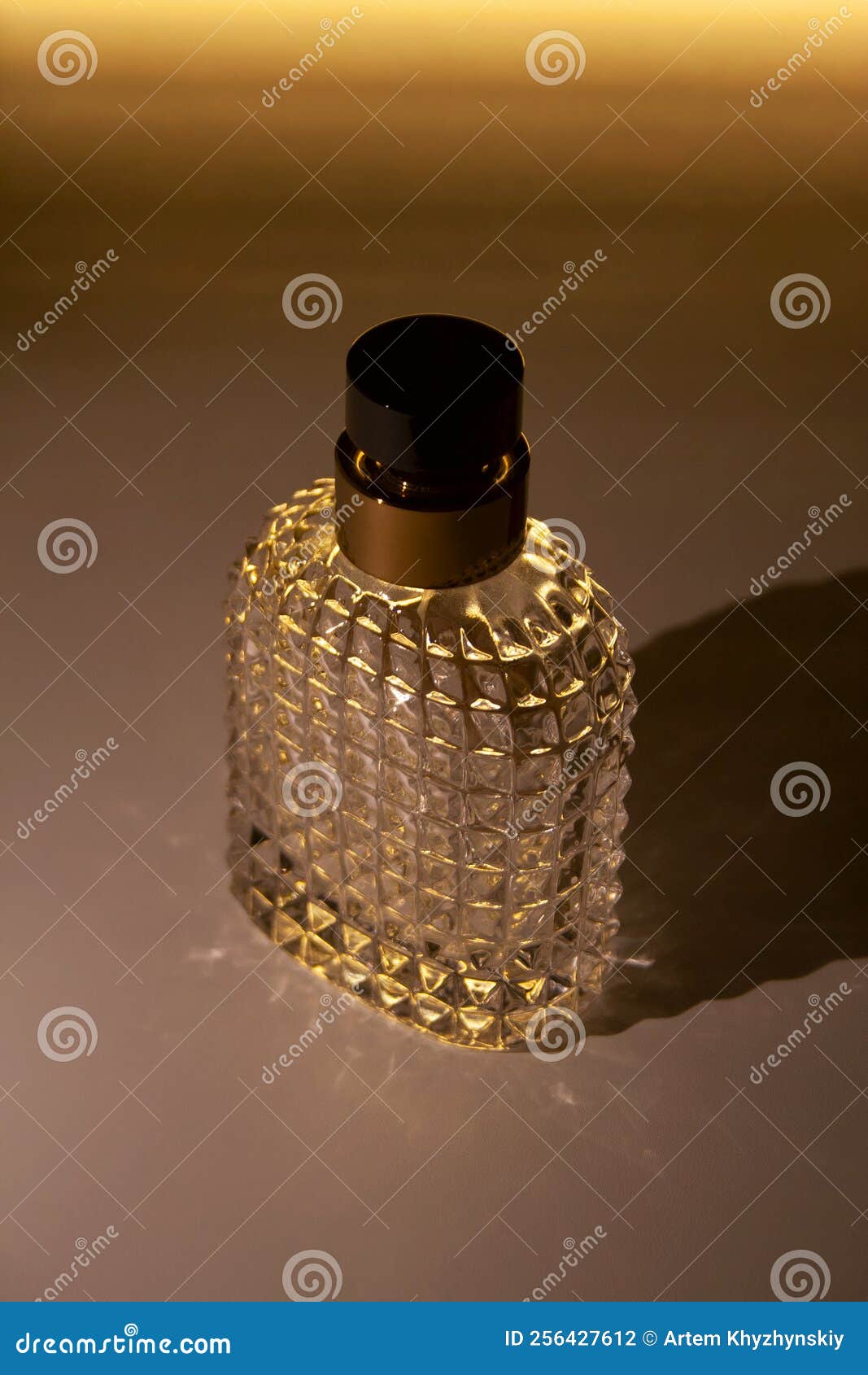 Textured Glass Perfume Bottle with Glowing Illumination Stock Photo
