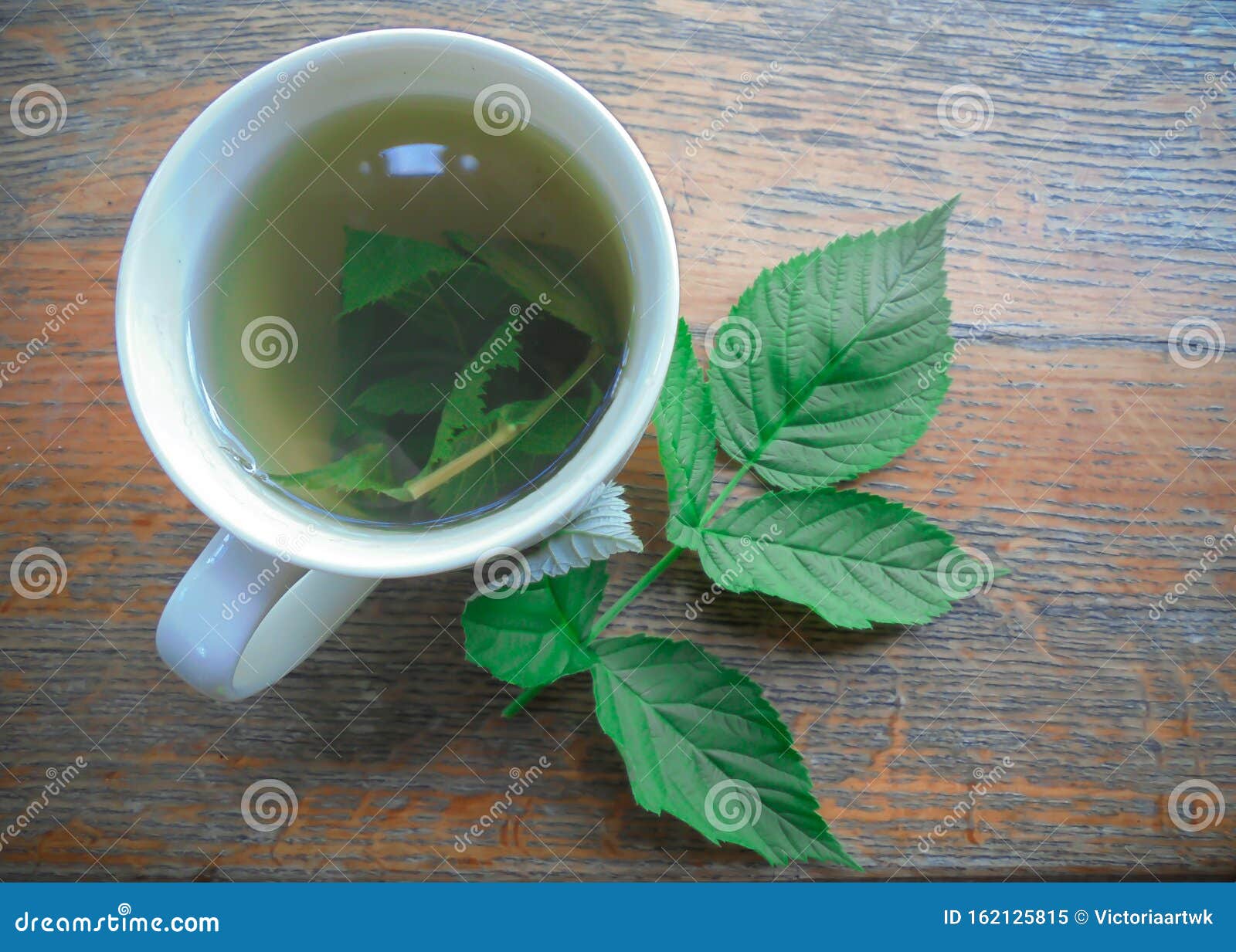 tisane dans une tasse blanche avec des feuilles de framboise