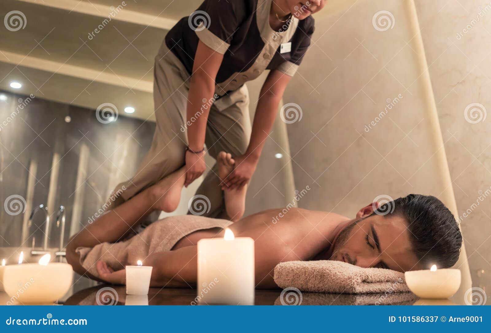 thai massage practitioner massaging man through stretching techn