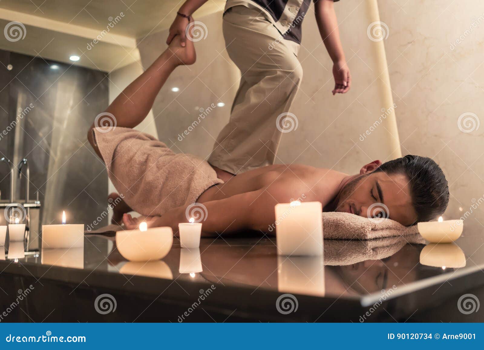 thai massage practitioner massaging man through stretching techniques