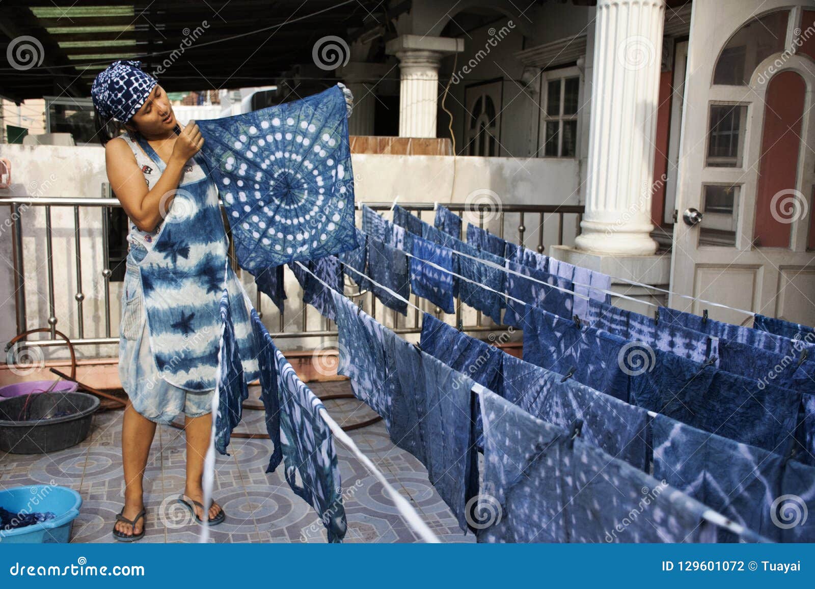 thai women working indigenous knowledge of thailand tie batik dyeing indigo color at outdoor on top of house at thailand