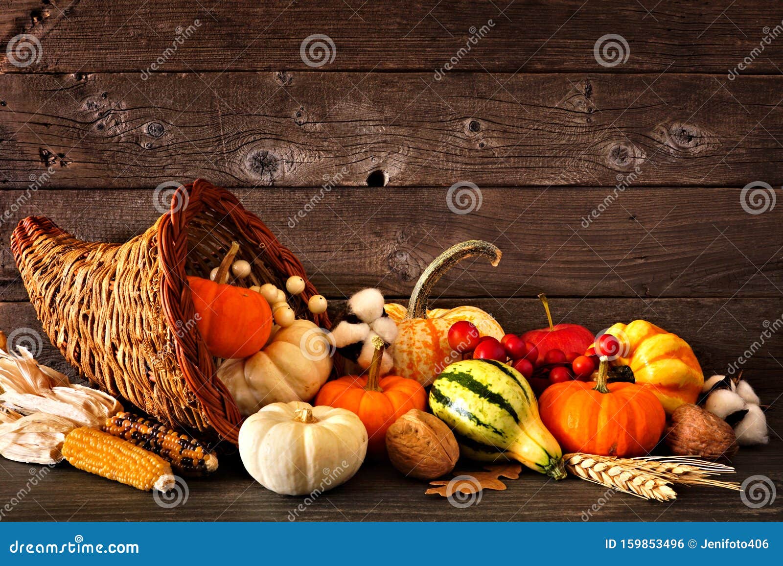 thanksgiving cornucopia filled with autumn pumpkins and vegetables against dark wood