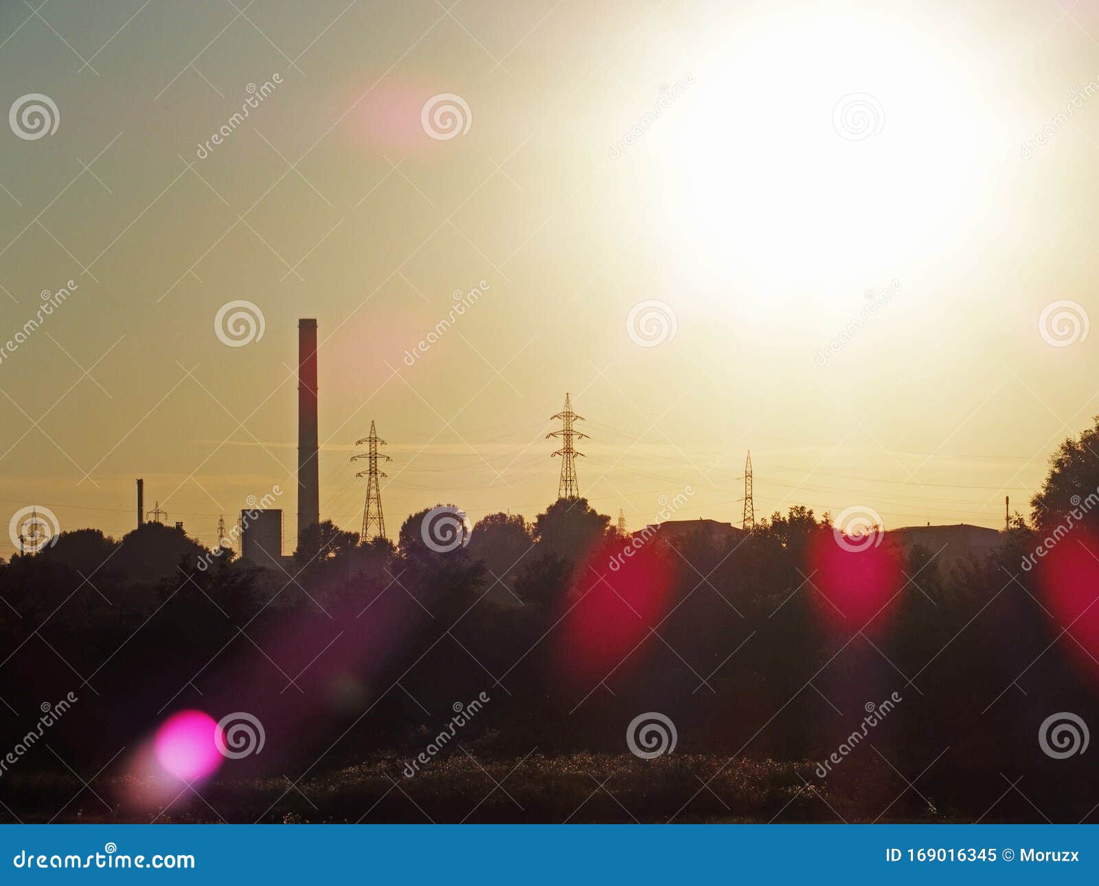 thermal power plant and electricity lines silhouette at sunset