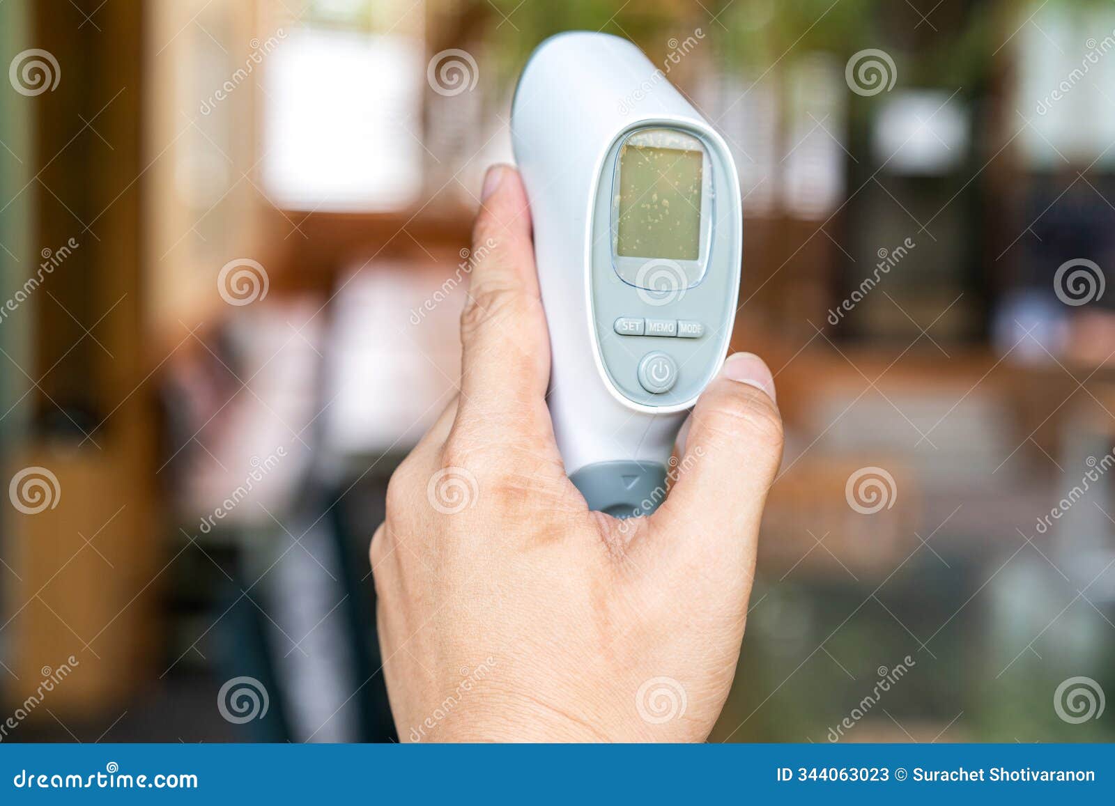 thermometer gun in man's hand.