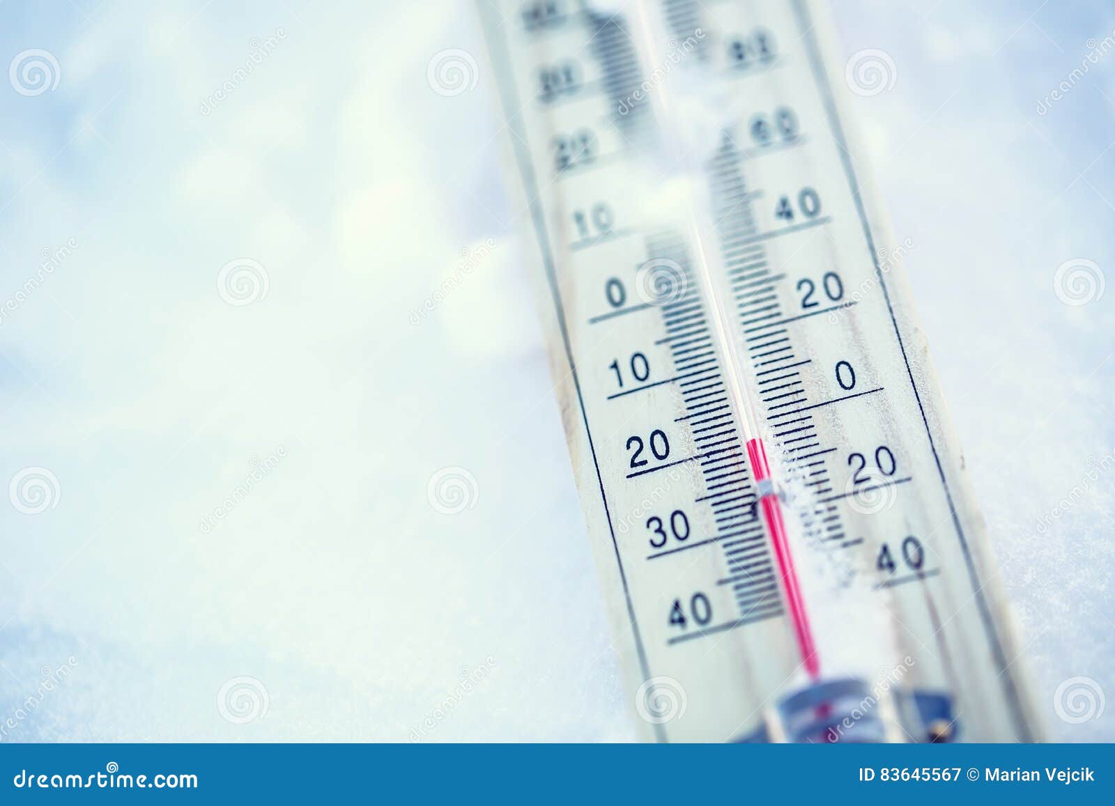 thermometer on snow shows low temperatures under zero. low temperatures in degrees celsius and fahrenheit.