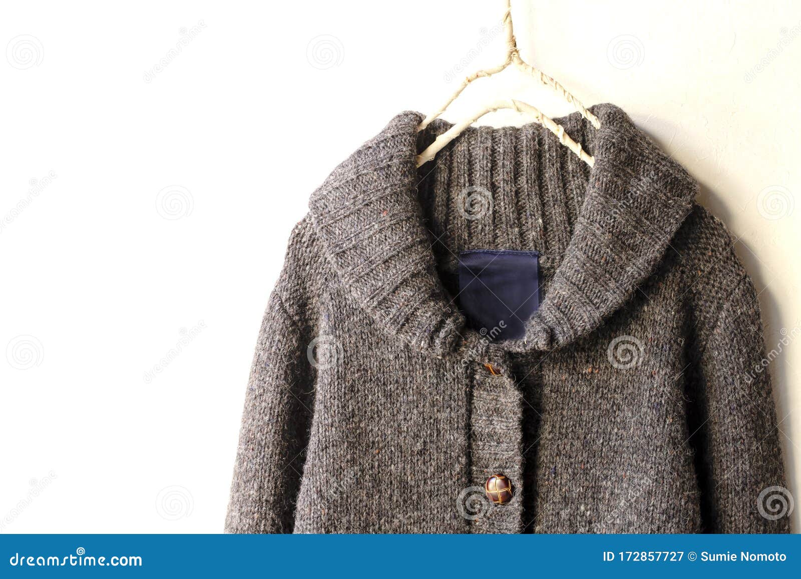 A Thick Knitted Cardigan in Brown Hanging on Clothes Hanger on White ...
