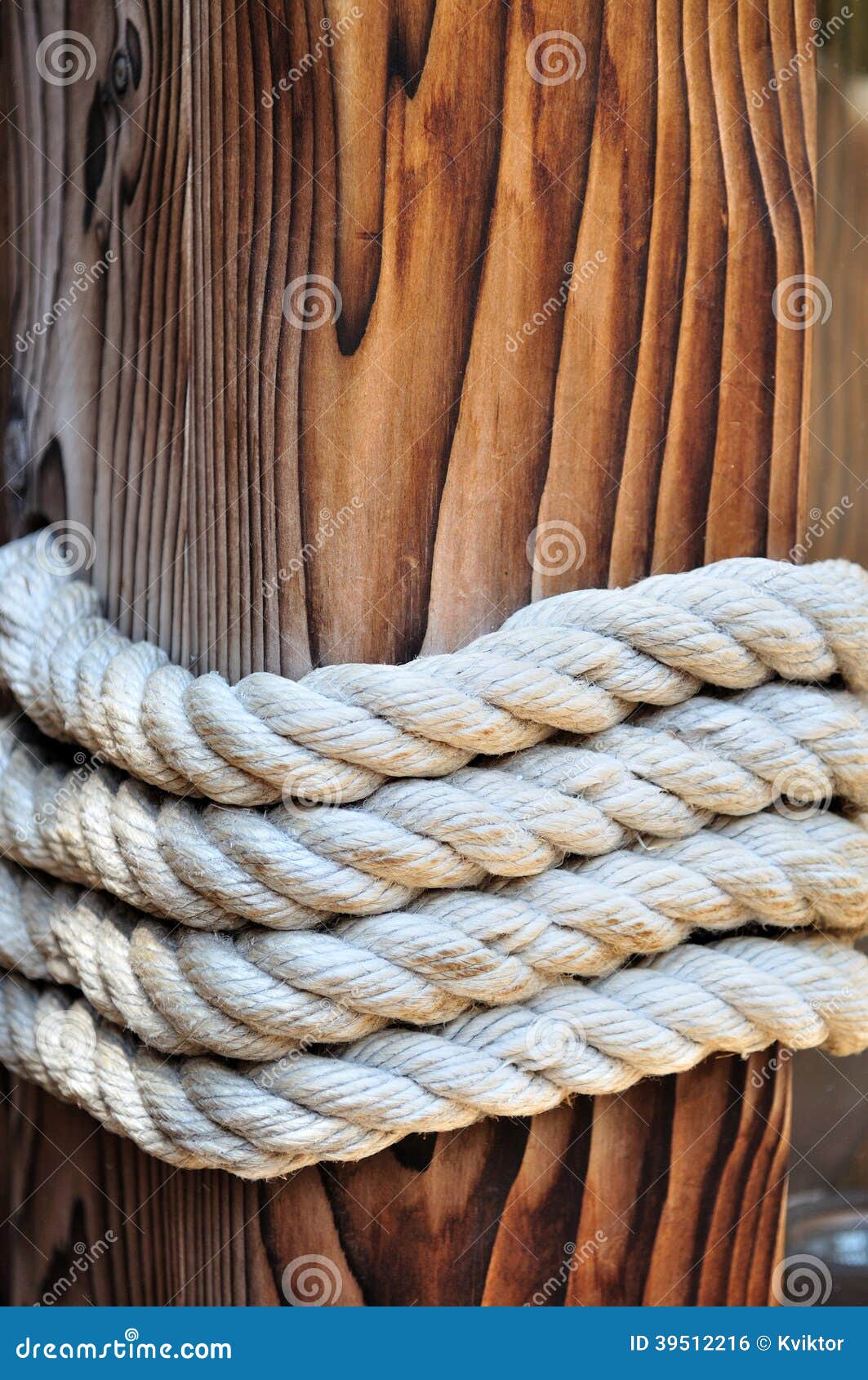 Thick Rope Around a Wooden Mooring Bollard, Croatia Stock Photo