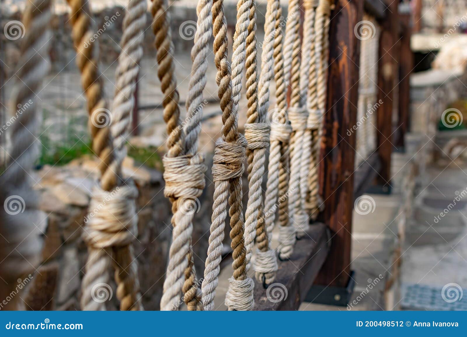 Thick rope ropes, intertwined crosswise, hang on wooden railings