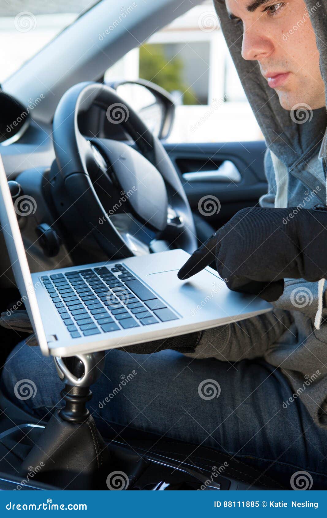 Thief Using Laptop To Hack into Car Security Software Stock Image