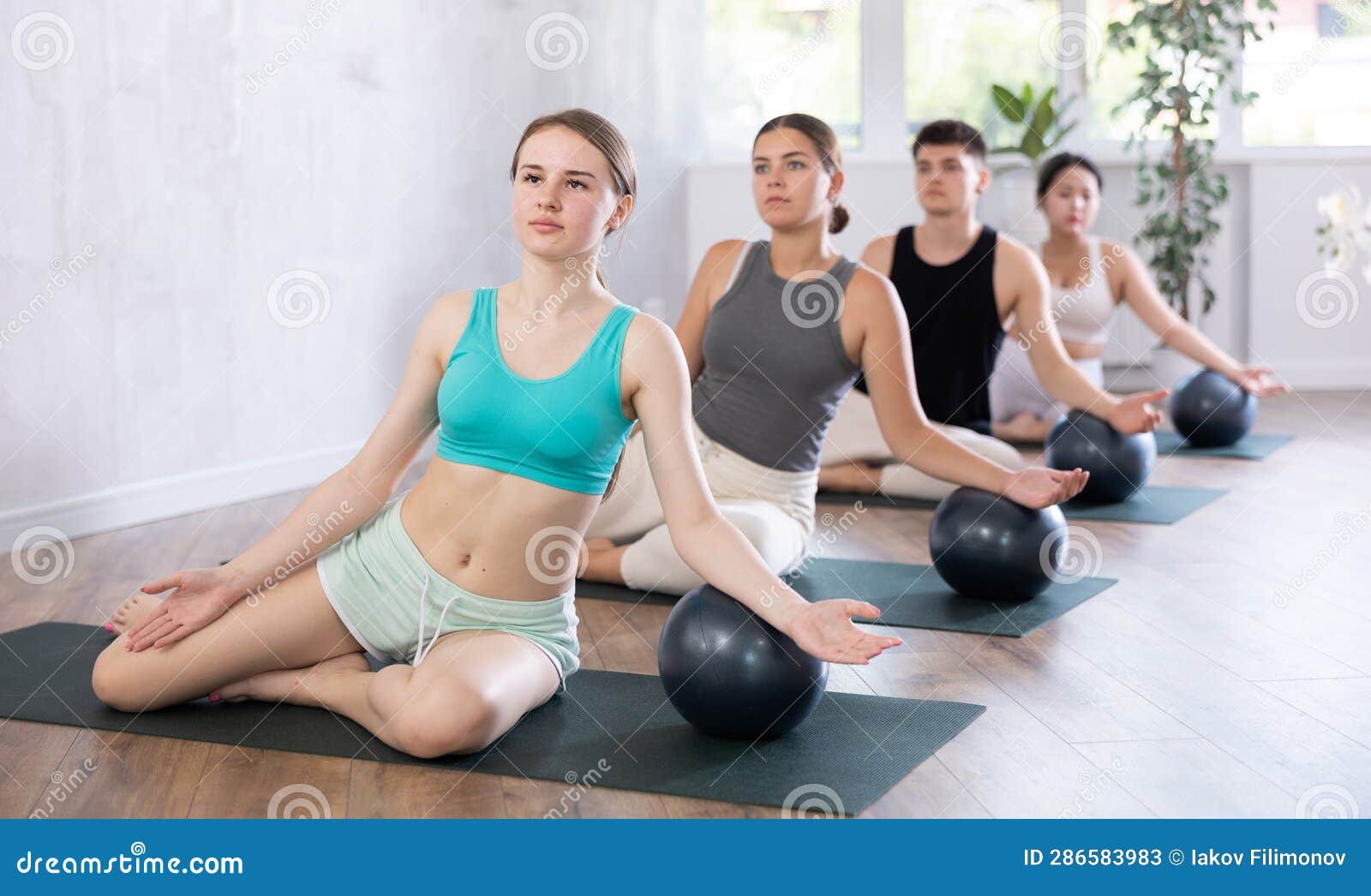 Young Girl Practicing Pilates Pose with Softball between Legs in Training  Area Stock Photo - Image of room, light: 305701190