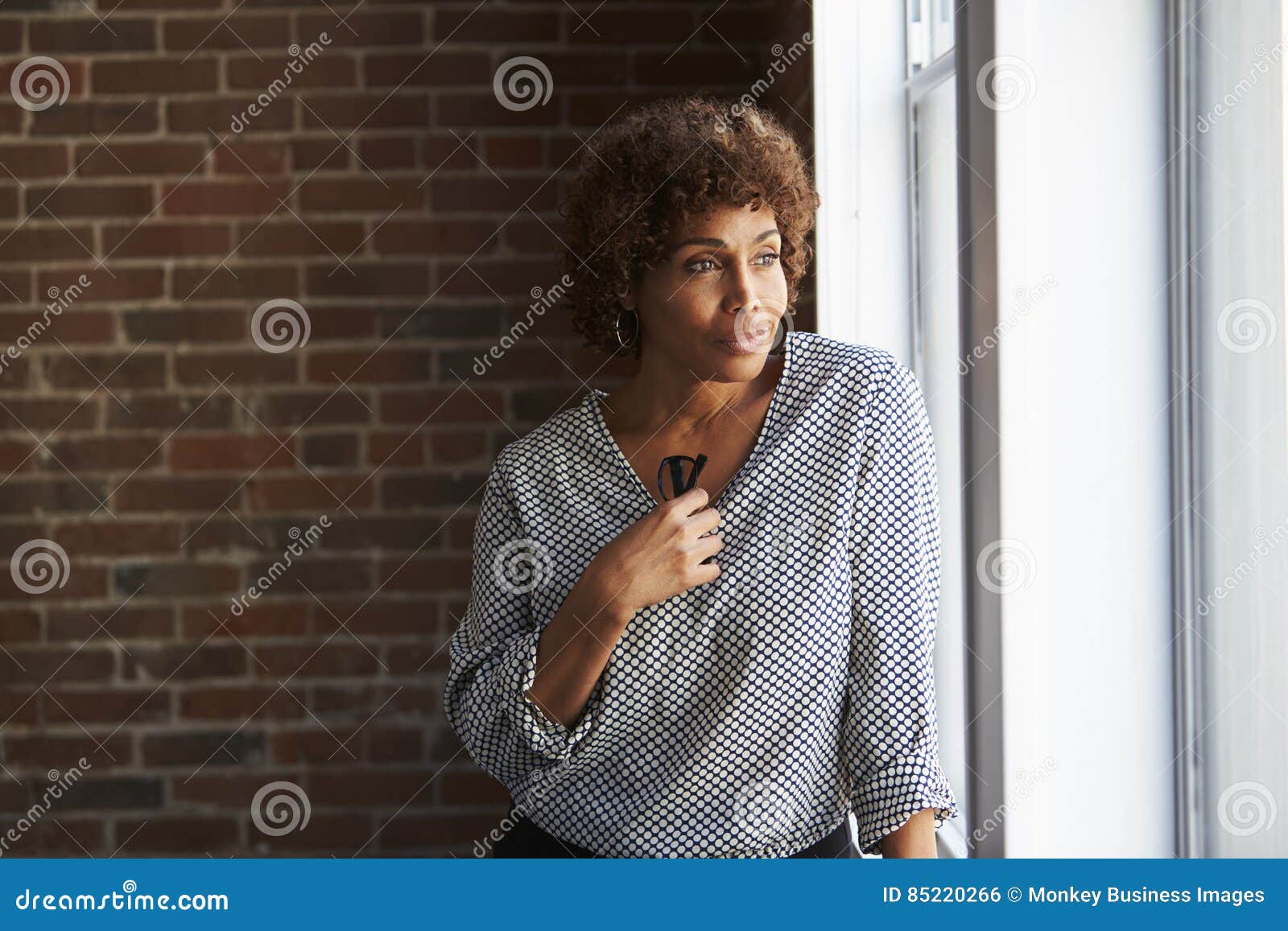 thoughtful mature businesswoman looking out of office window