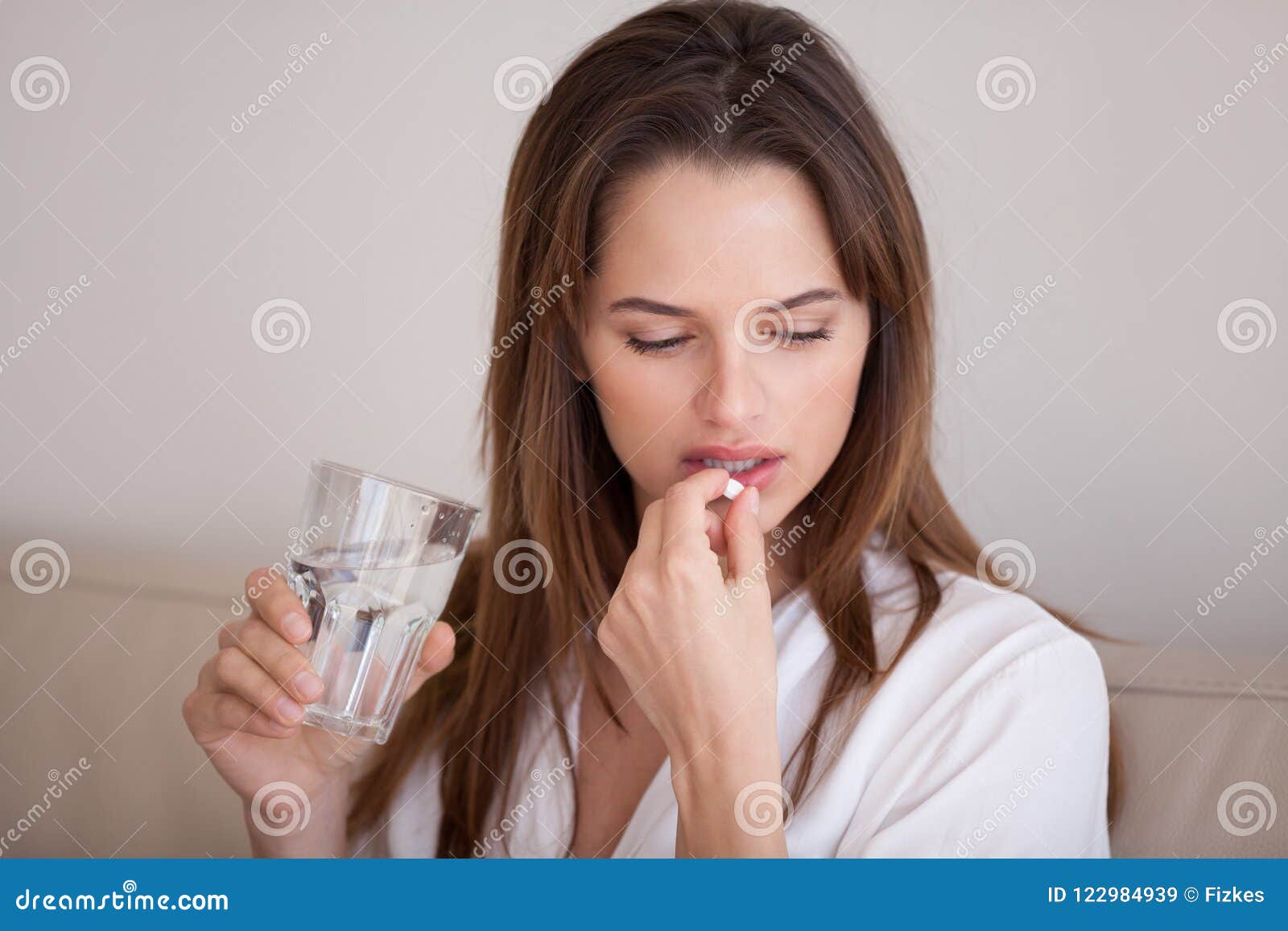 sad millennial woman taking pill to cure pain or depression