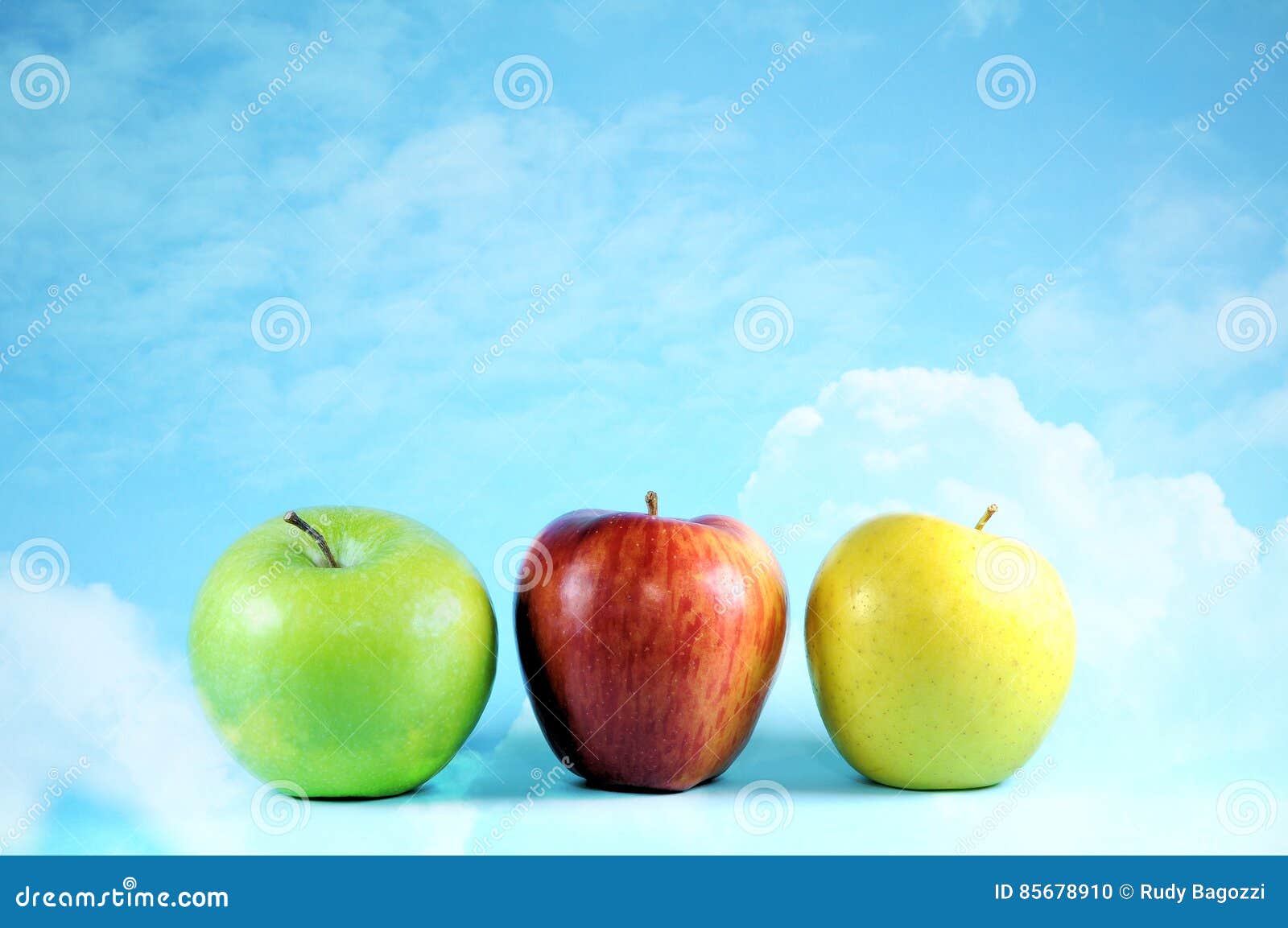 Three Apples on Bright Sky and Clouds. Stock Photo Image of food
