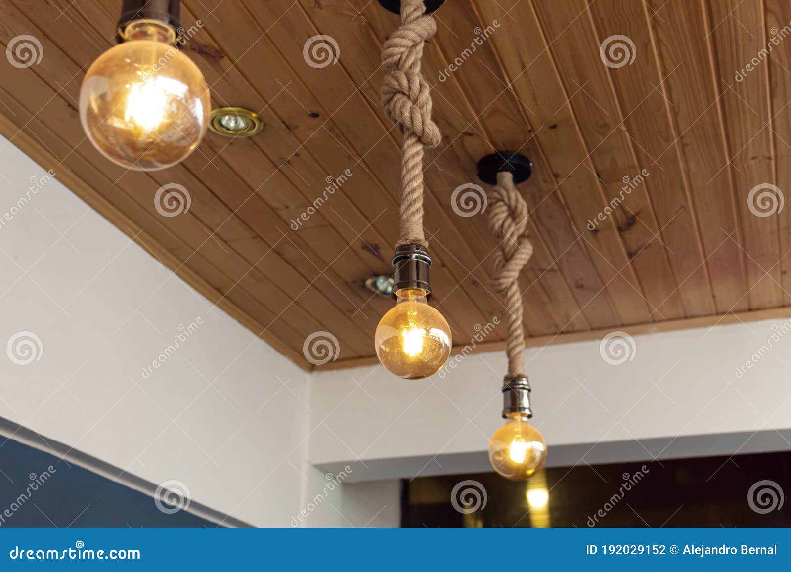 three artesanal yellow light bulbes with wooden roof and blue & white paiting