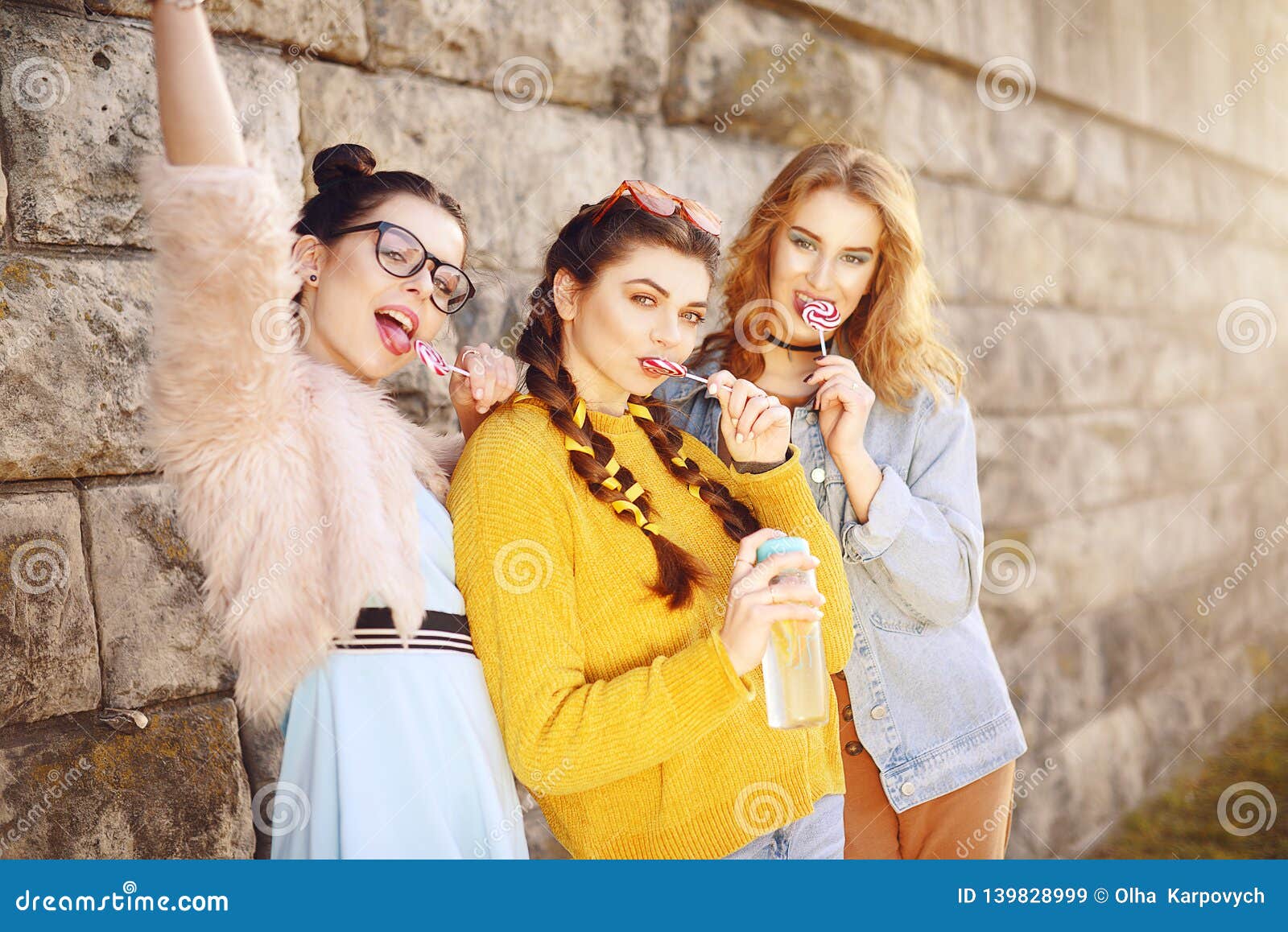 Three Beautiful Girls Eat Lollipops And Drink Lemonad In