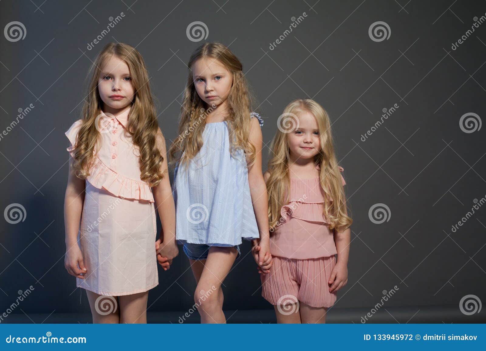 Three Beautiful Little Girls Sisters Portrait Fashion Grey Background