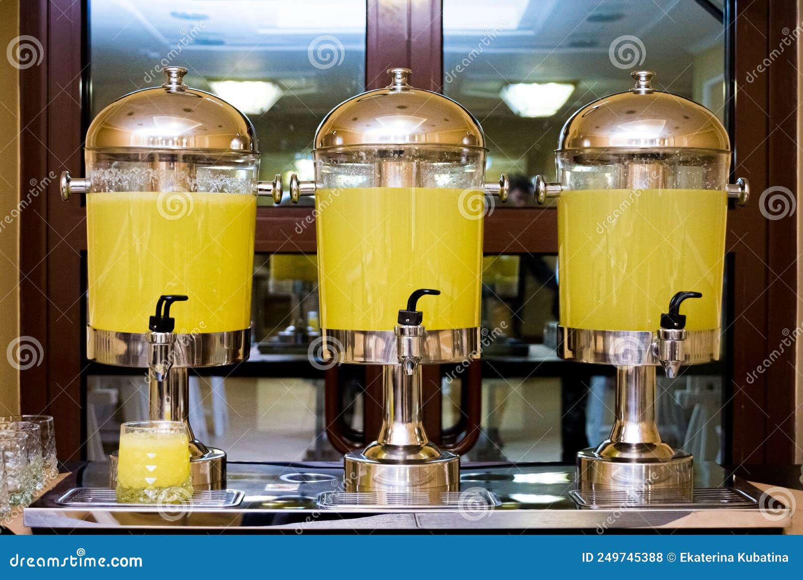 Three Beverage Dispensers with Lemonade Standing on the Table Stock