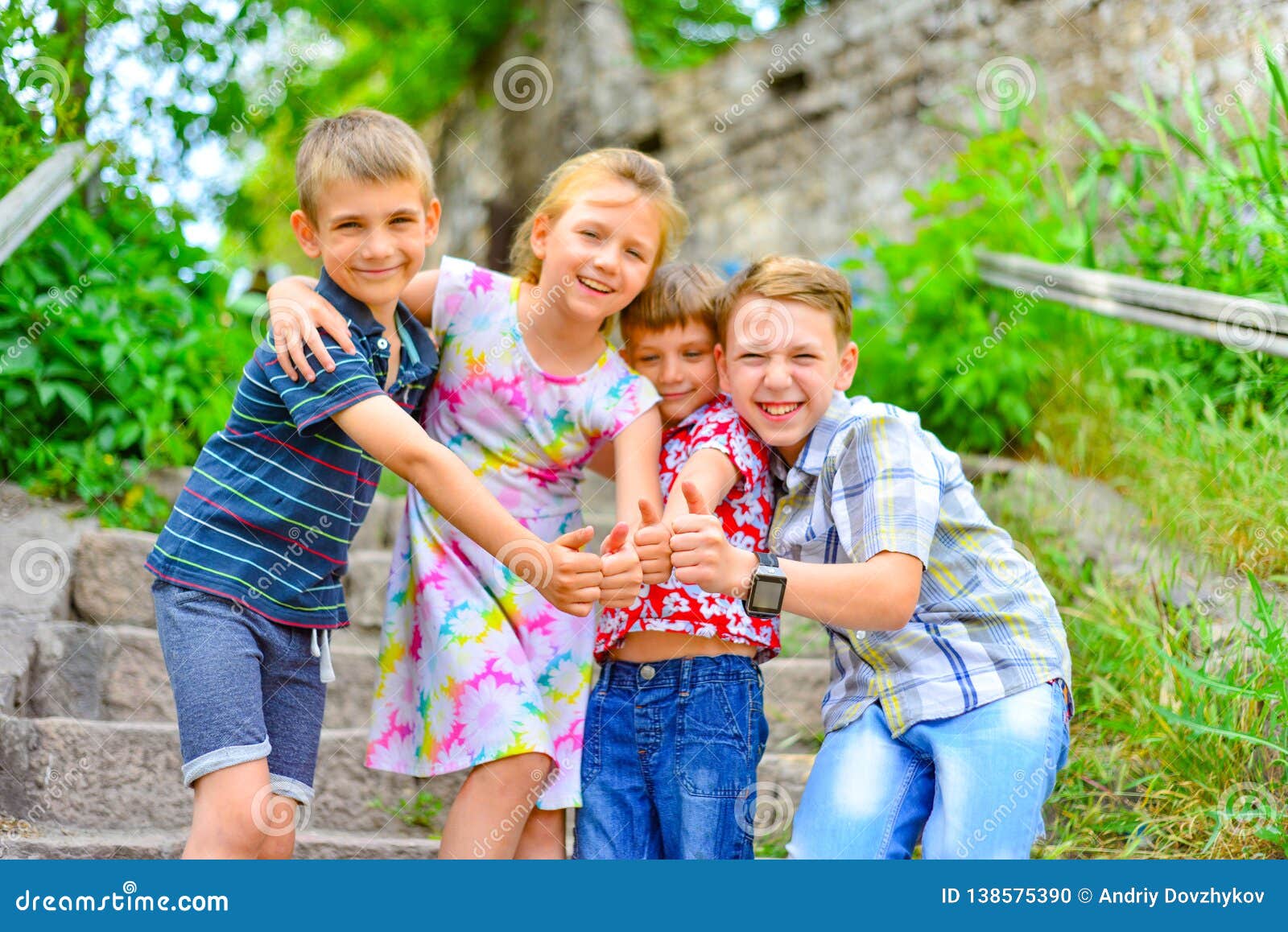 Three Brothers and Sister Stand on the Steps in the Park and Show the