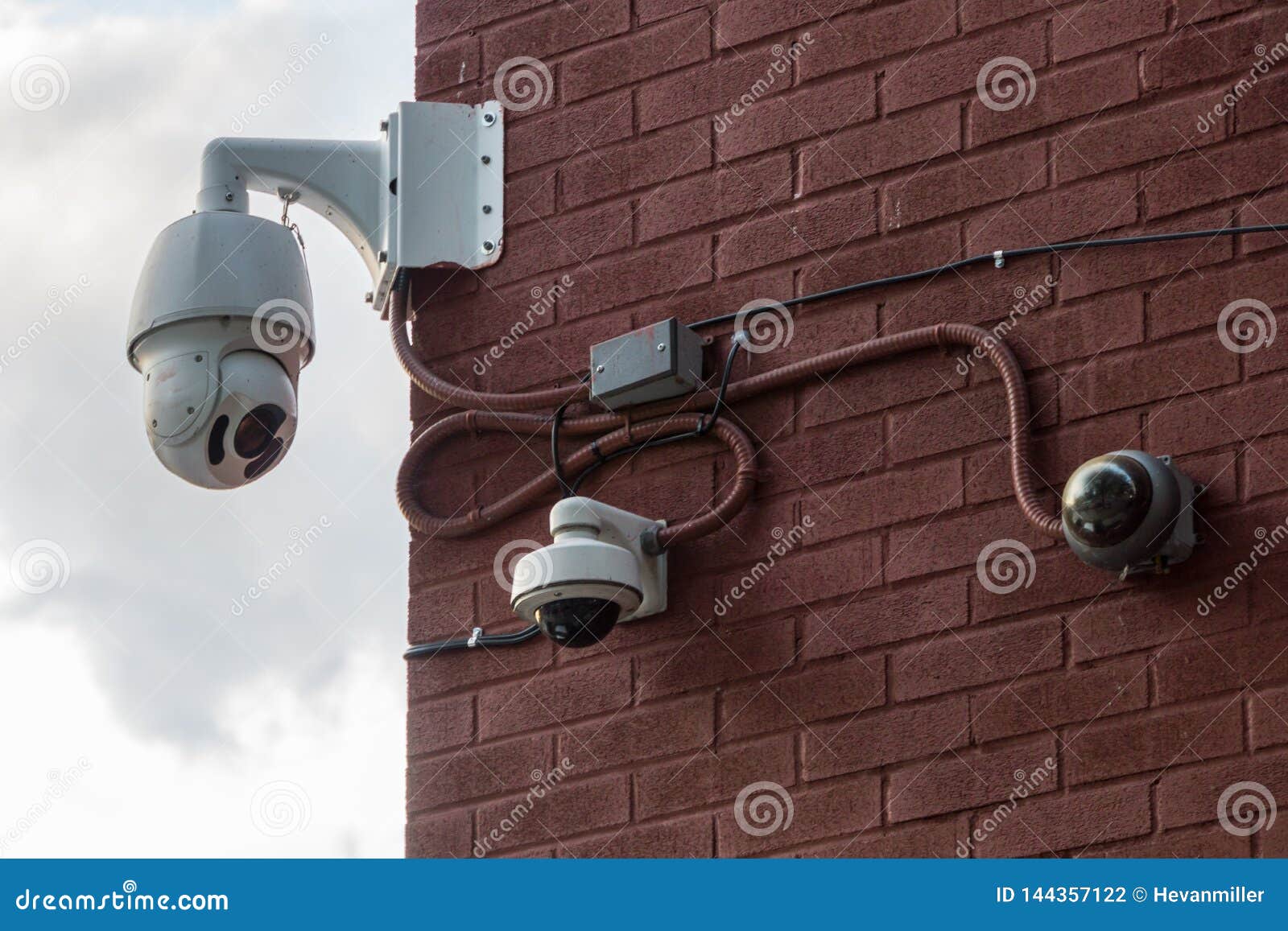 Three Security Cameras Mounted on a Red Brick Wall Stock Photo Image